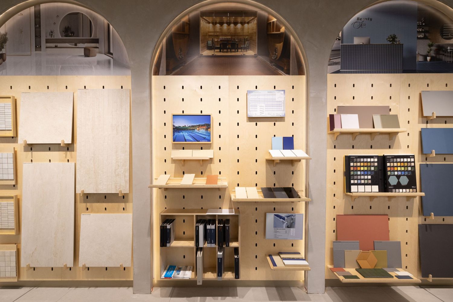 Contemporary showroom displaying various home fixtures and design elements with arched doorways and pegboard walls.