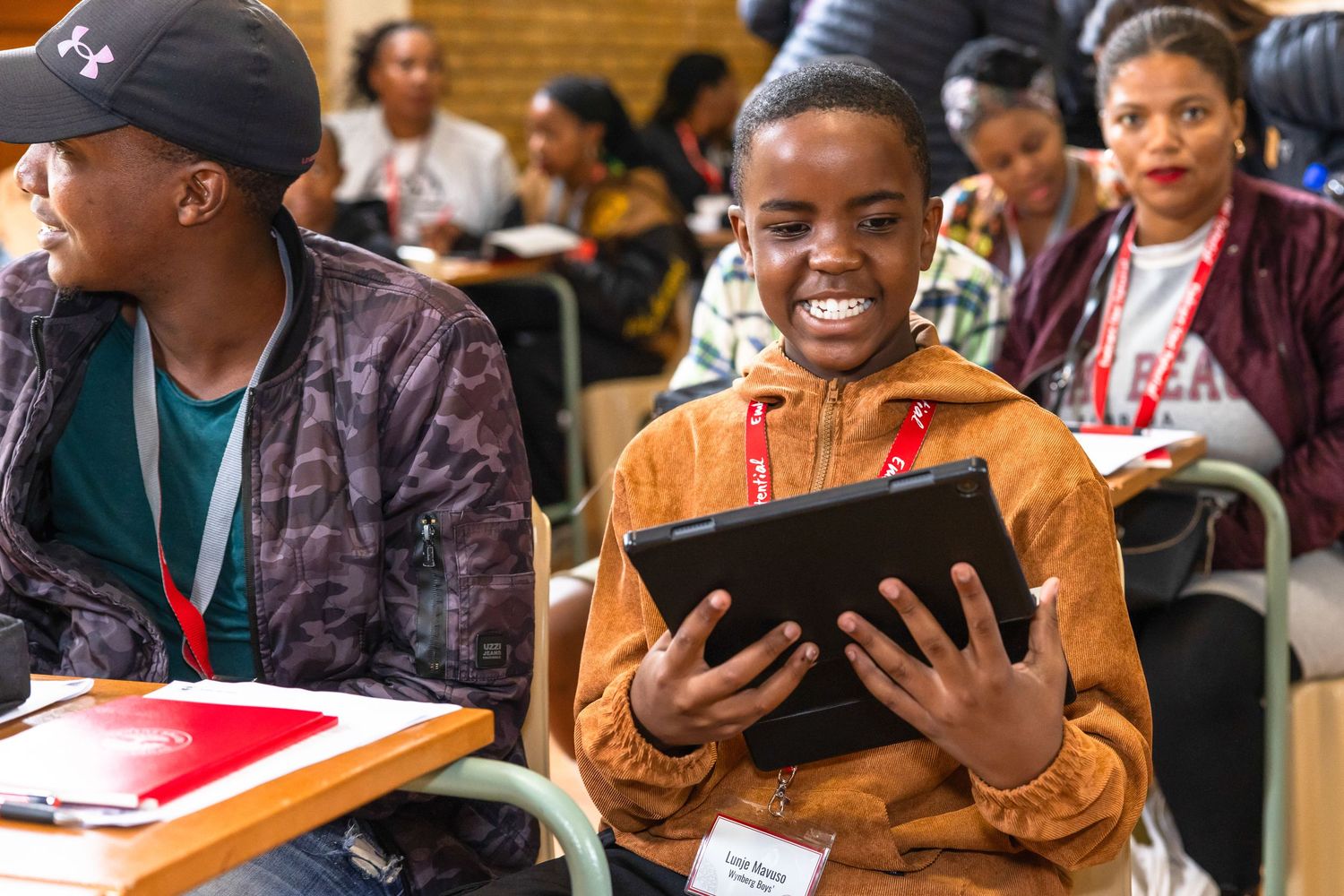 Students engaging with digital devices during an educational workshop.