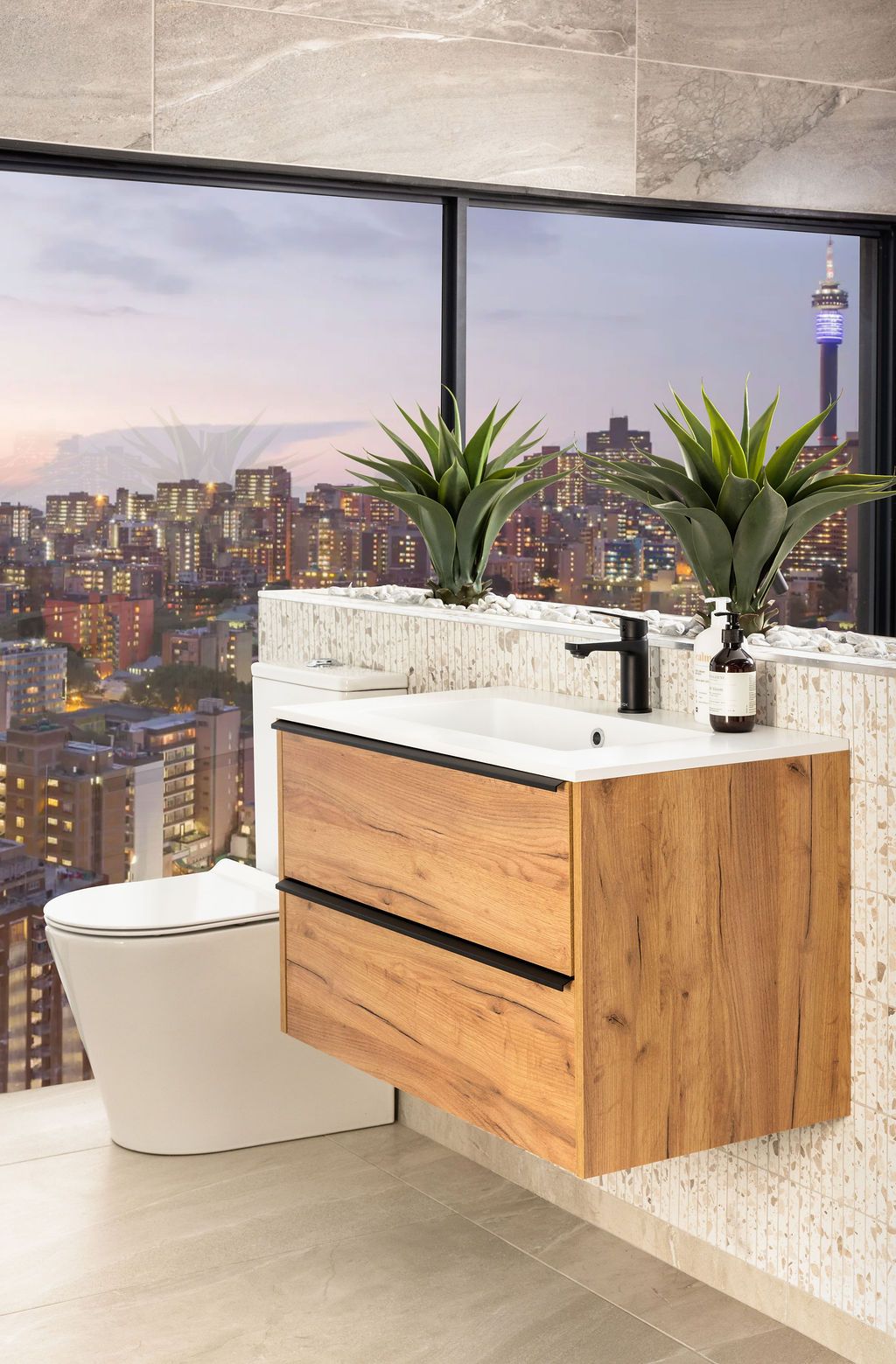 Contemporary bathroom vanity with wooden cabinets and white countertops against a backdrop of city skyline views.