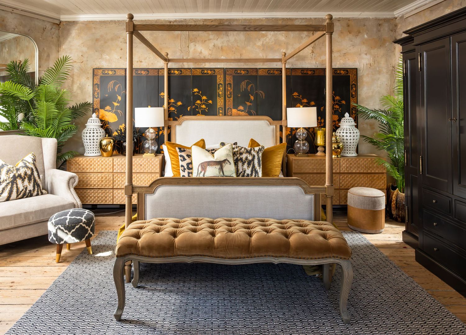 Luxurious bedroom display featuring canopy bed, tan bench, and modern coastal decor elements.