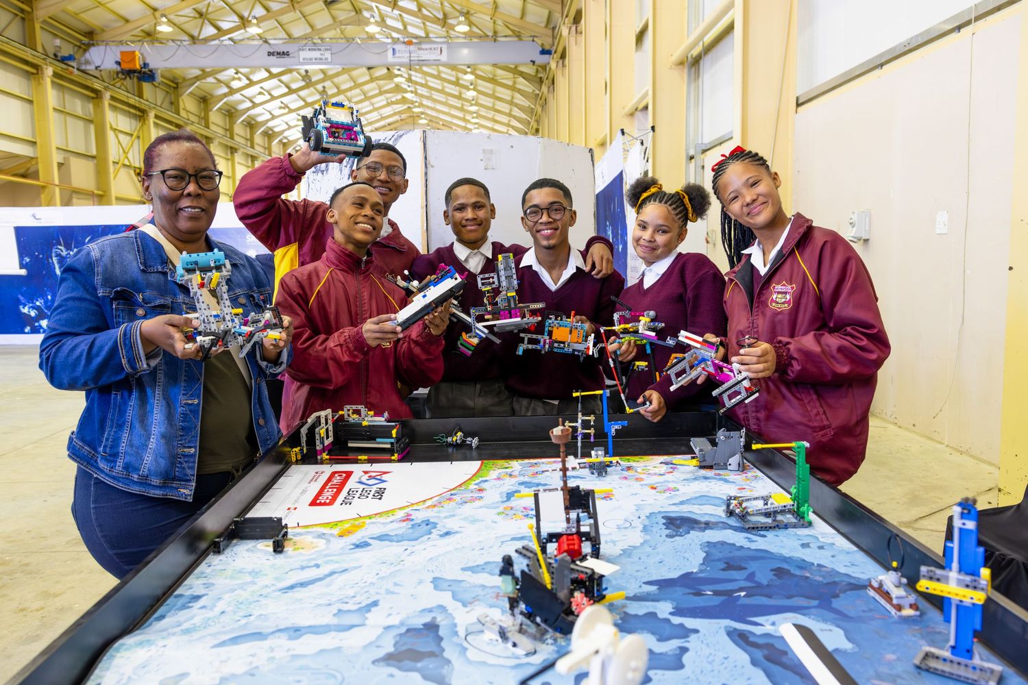 Team collaborates around table with robotic projects during educational workshop.