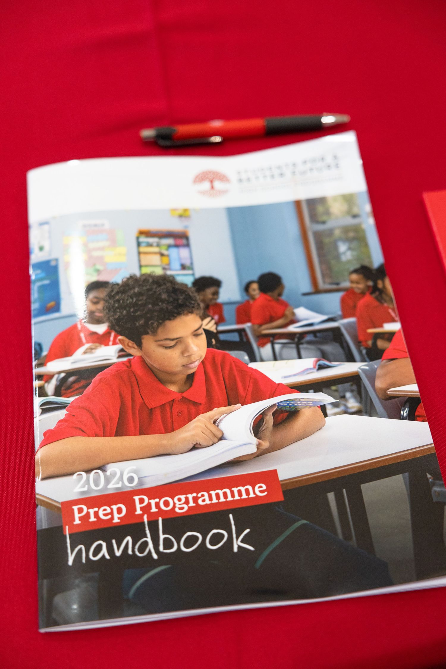 A 2026 prep programme handbook displayed on a red background with pens.