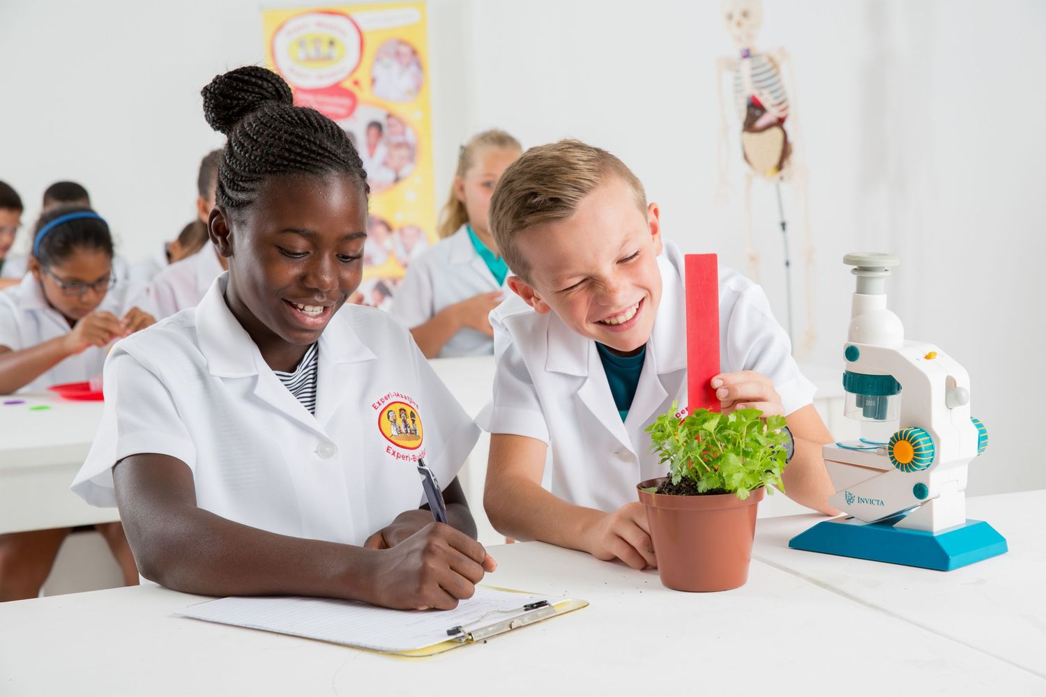 Students in white uniforms working on science experiment with plants in classroom laboratory.