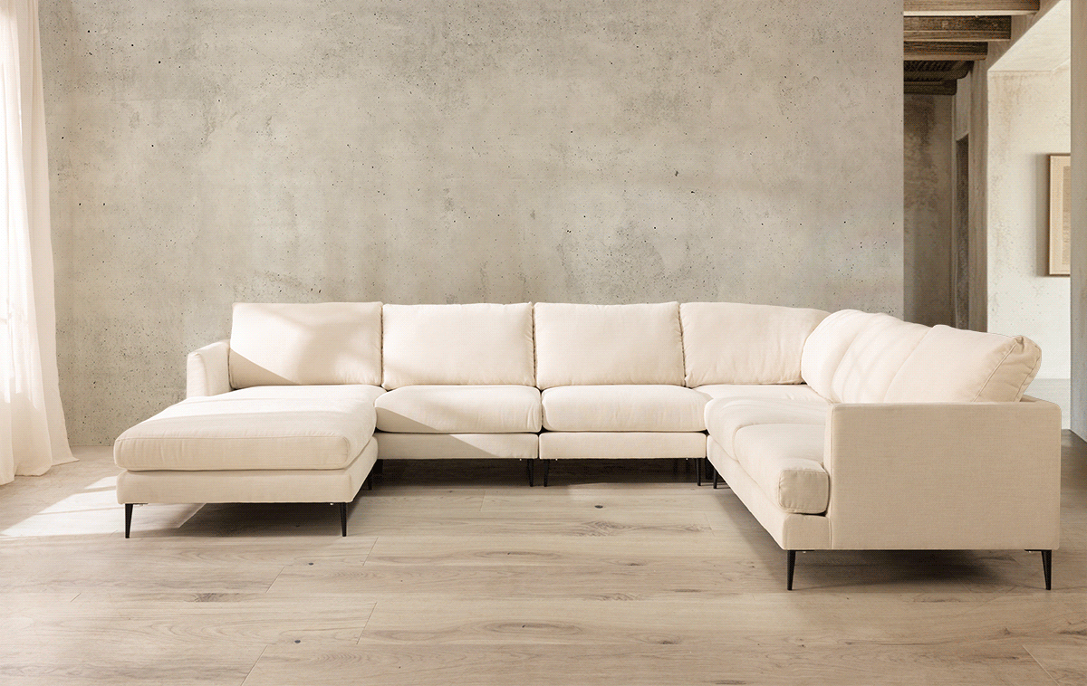 Modern white sectional sofa displayed in a clean, minimalist showroom space.