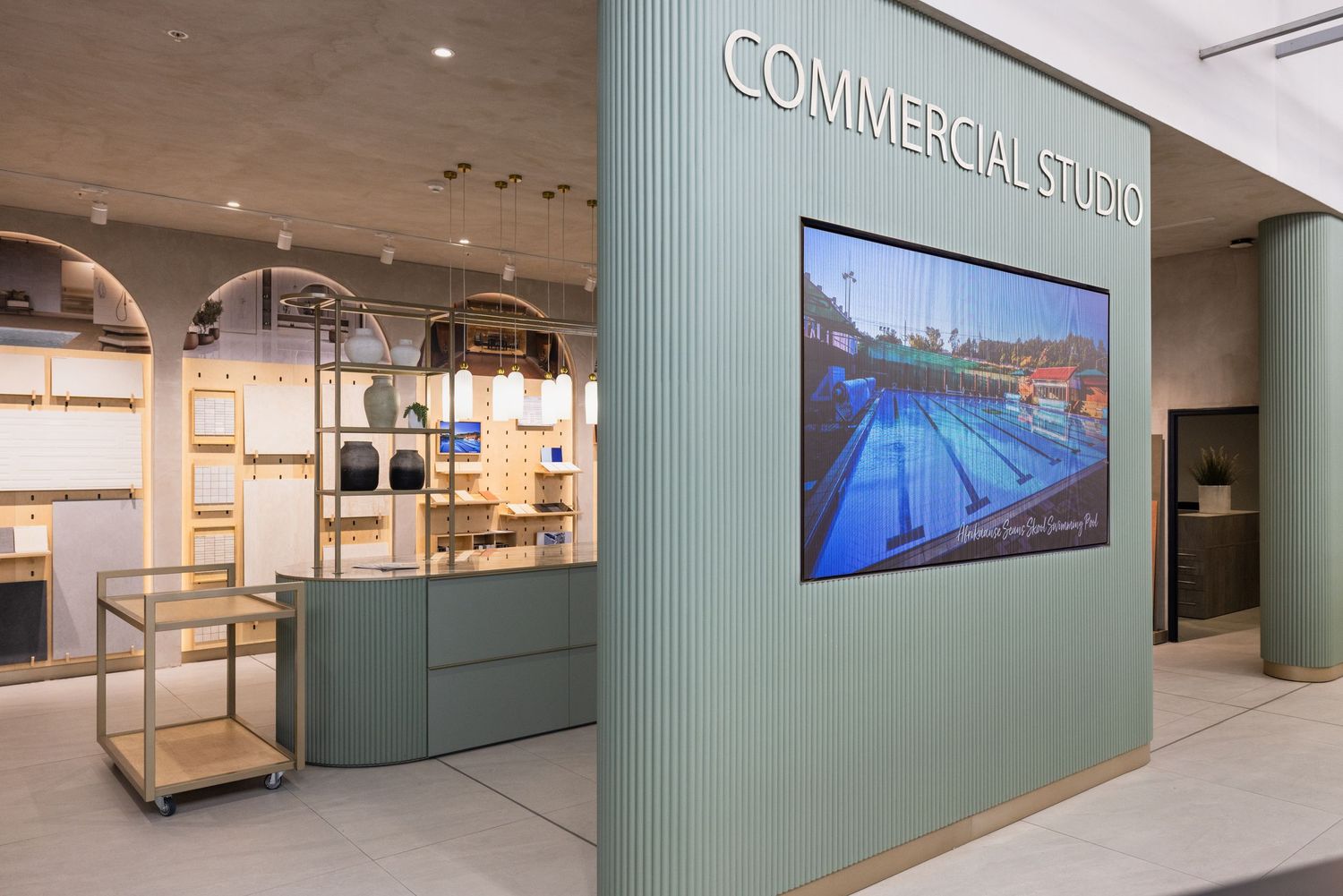 Modern office interior with green walls and digital displays showcasing communications and design elements.