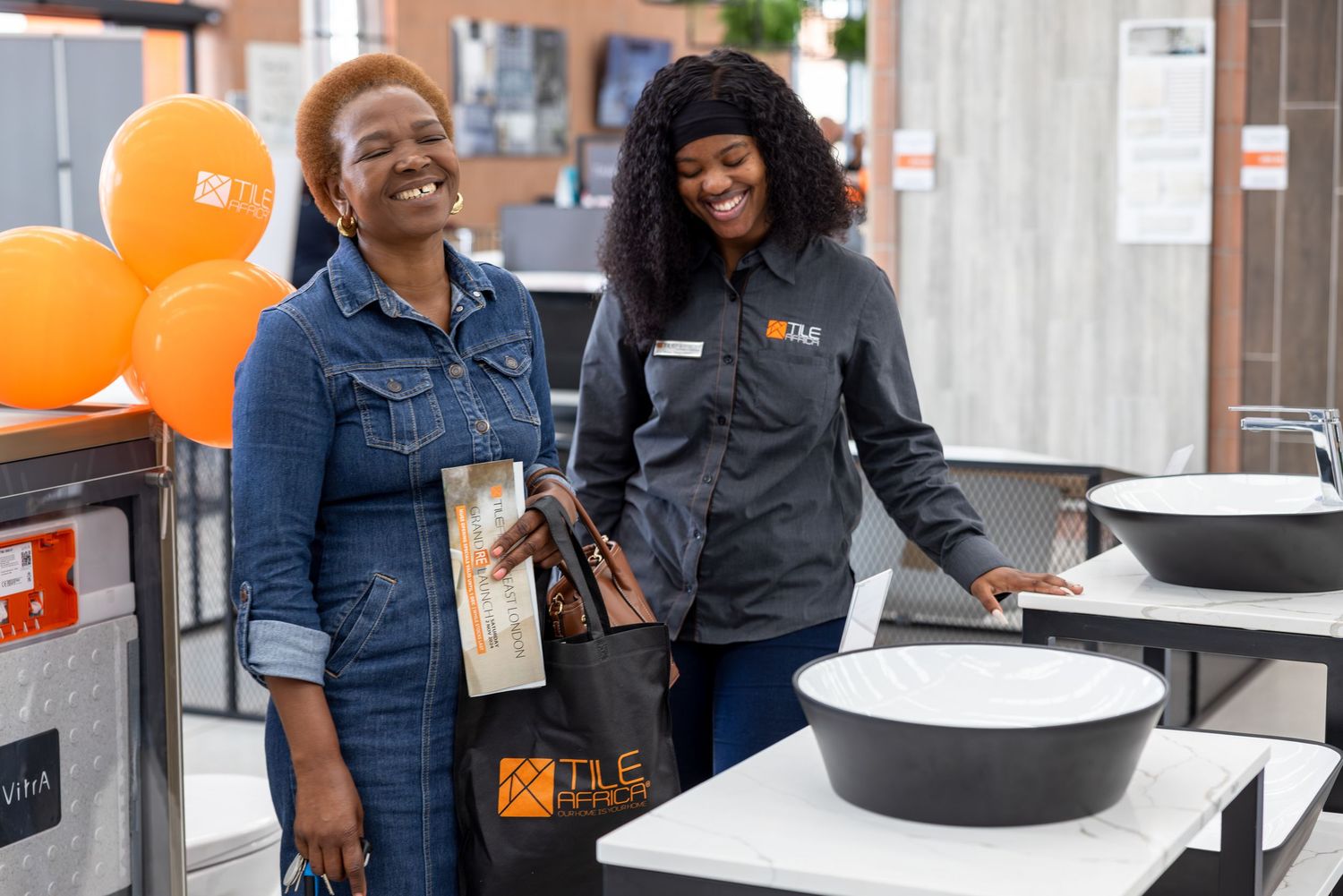 Group gathering in retail space with orange balloons and wooden displays.