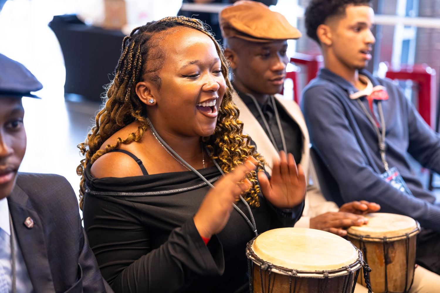 Enthusiastic participant plays drums during an interactive music workshop.