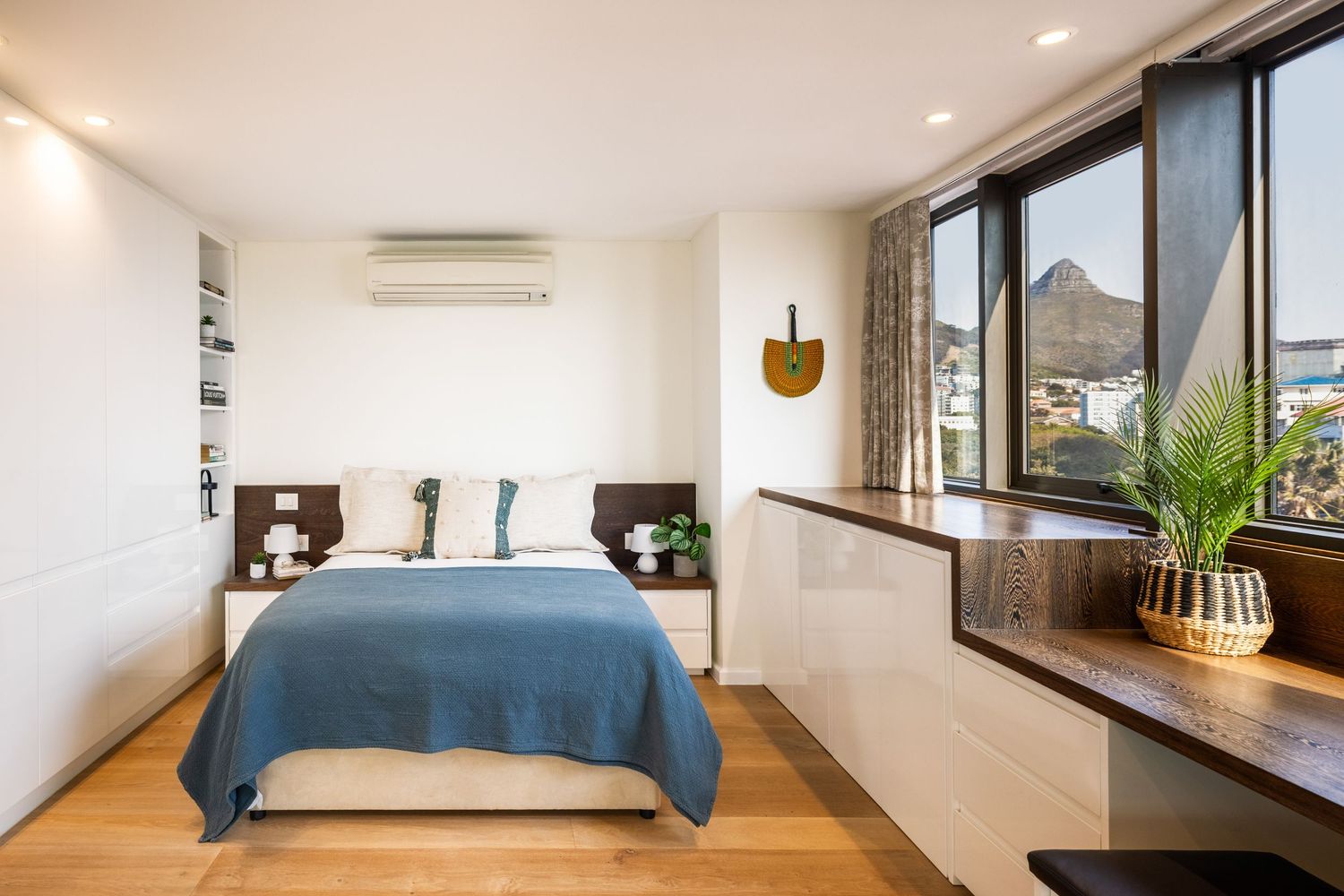 Contemporary bedroom with blue bedding and wooden window frames shown from different perspectives.