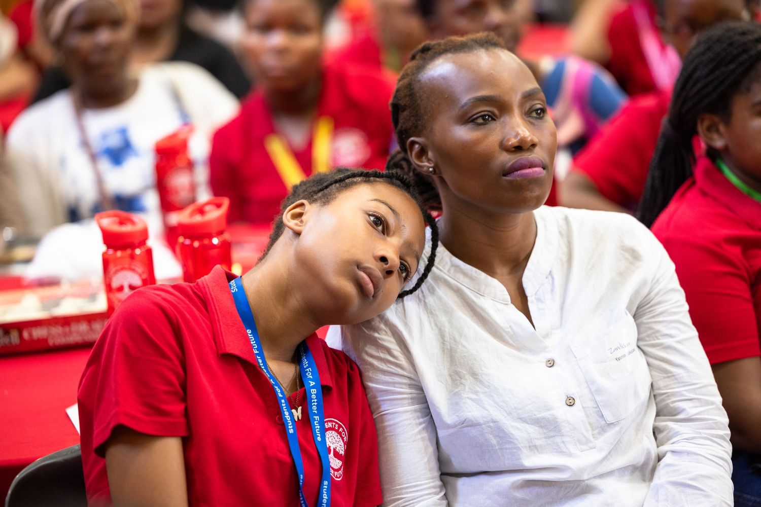 Students in red and white attire engage in discussion at a classroom gathering.