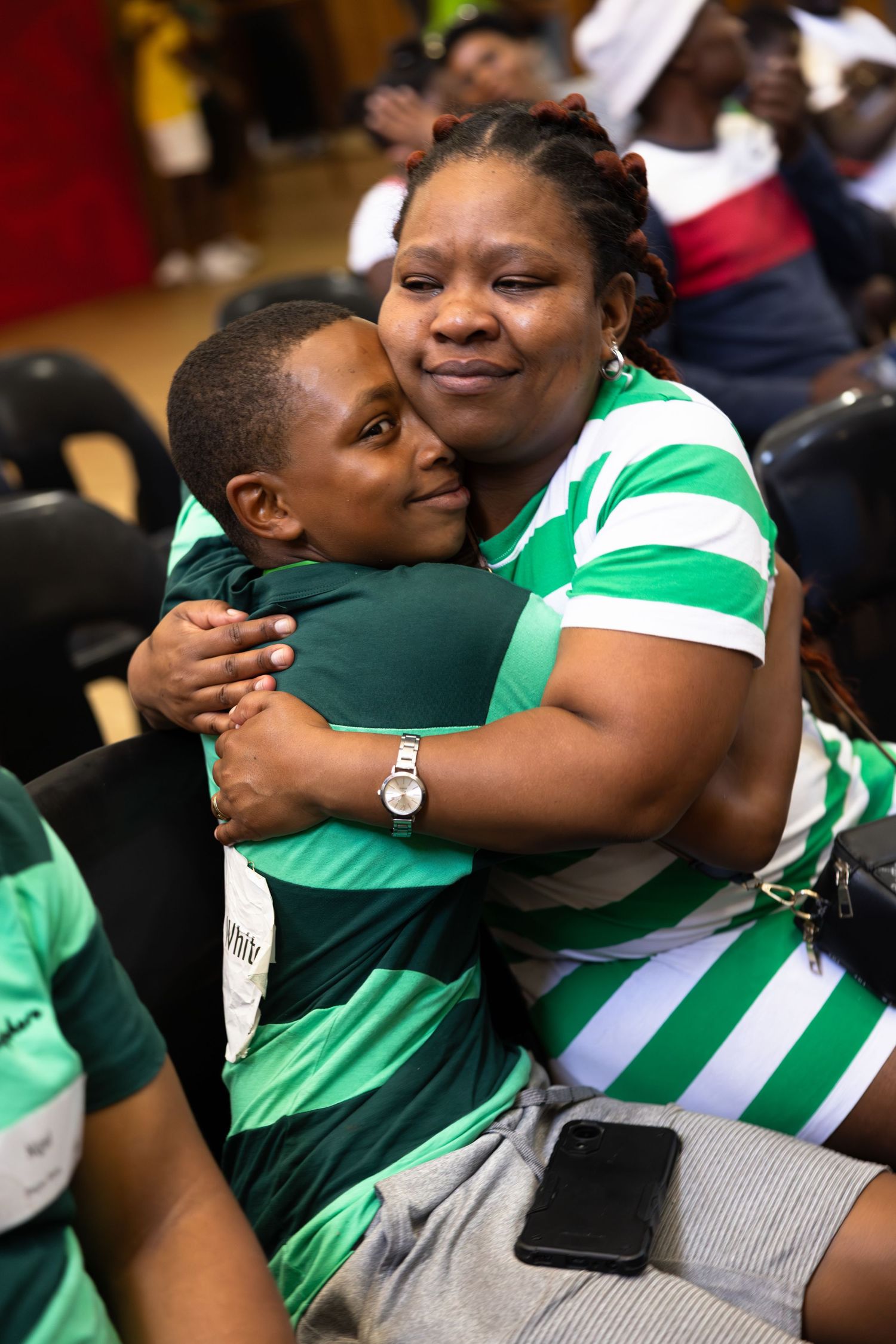 A mother hugs her son upon hearing that he has won a scholarship with Students for a better furture.