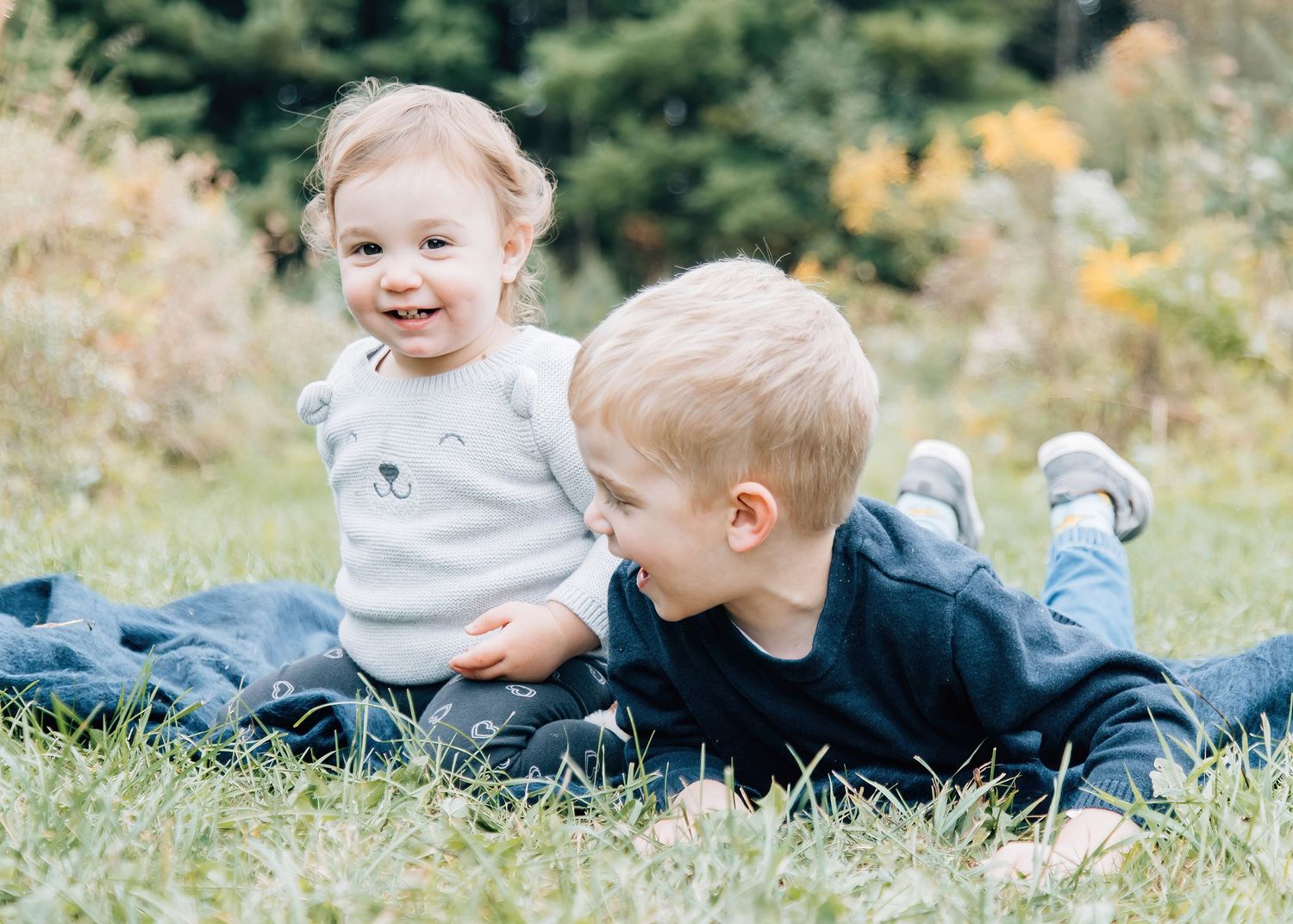 Children playing and laughing together in a grassy meadow during summer.