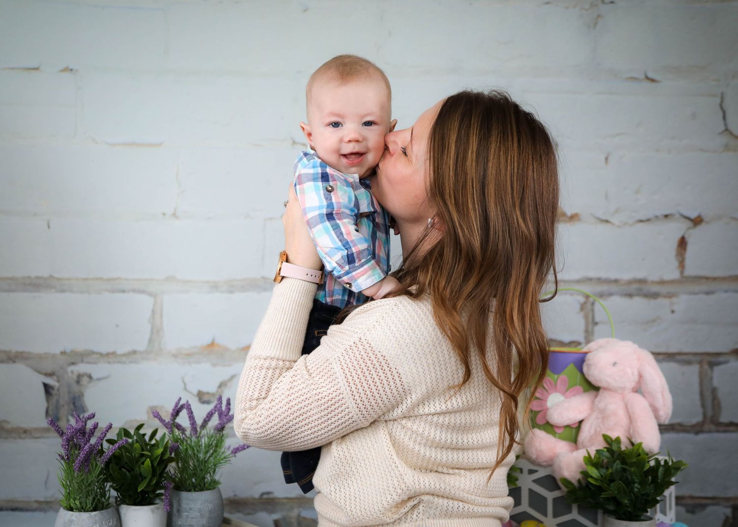 Sweet indoor family moments shared against a white brick wall with lavender plants.