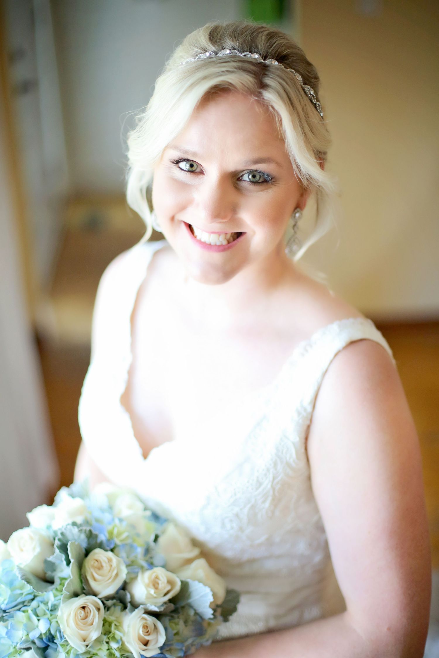 A bridal portrait series showing a white wedding dress and delicate bouquet of cream roses and blue flowers.