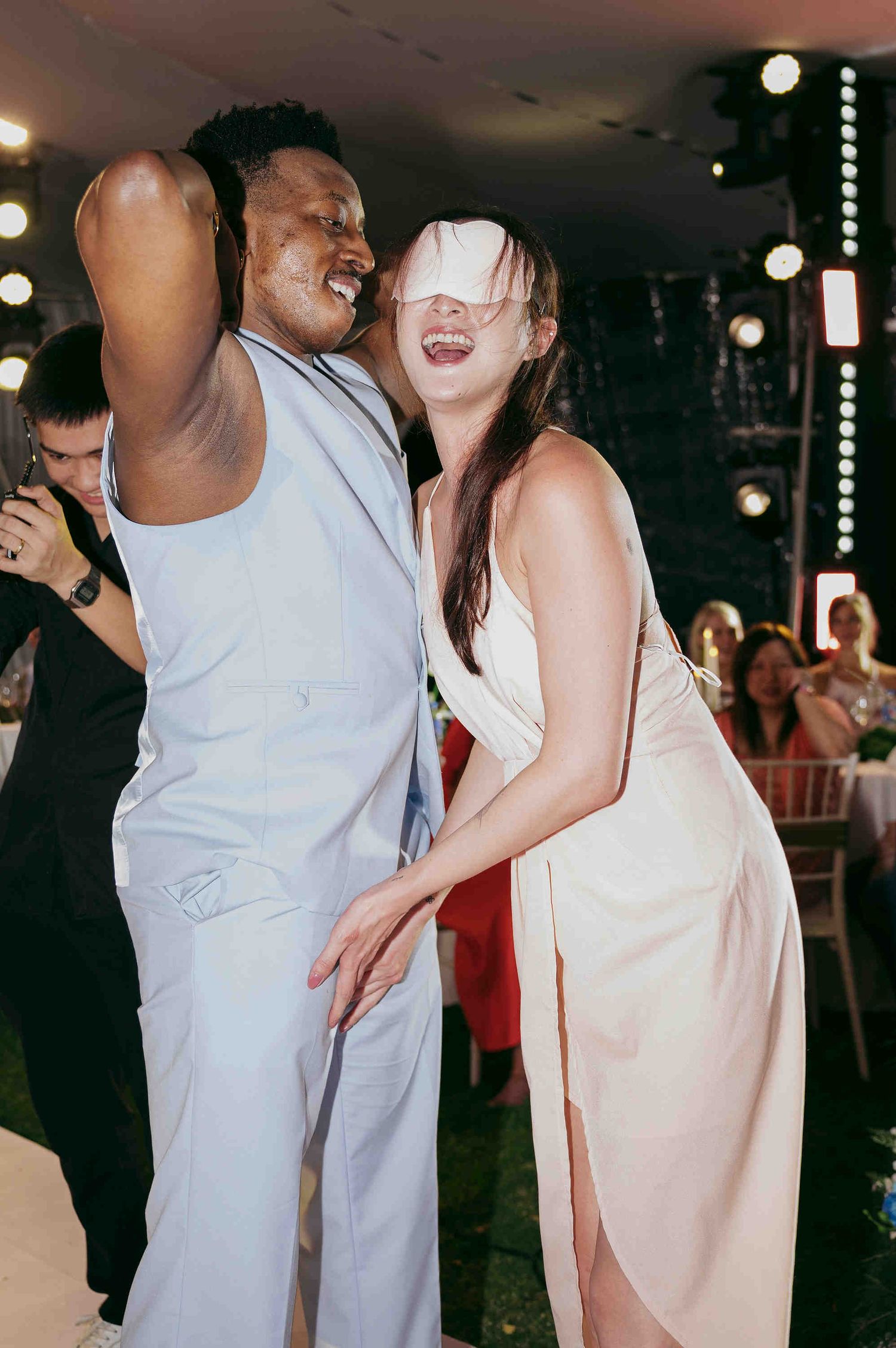 Two guests laughing and dancing together at an elegant wedding reception party celebration.