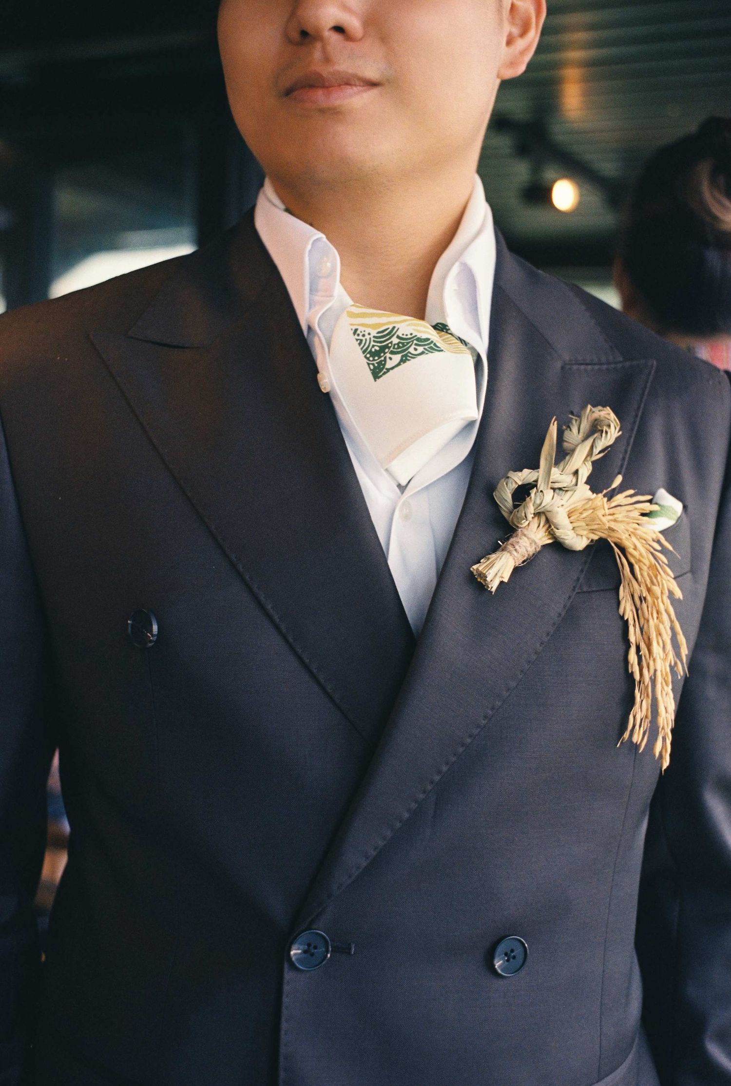 wedding: formal suit detail showing wheat boutonniere against dark jacket, by AnhVuWedding.
