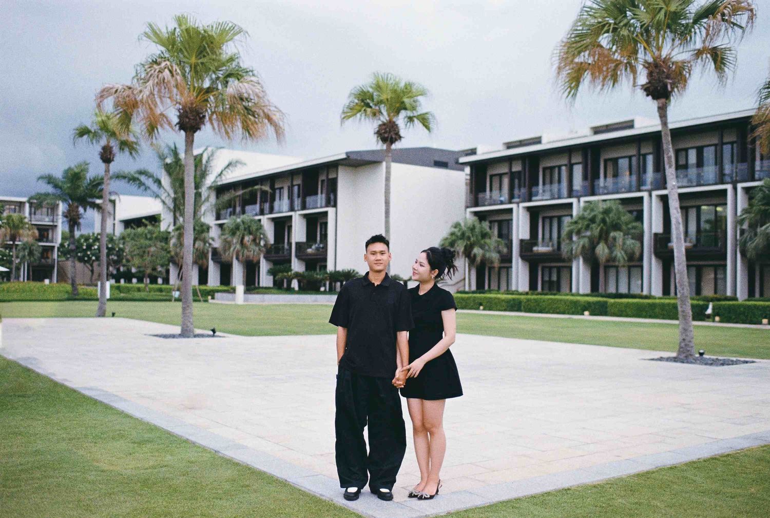 Da Nang family: couple poses together on a manicured lawn, by AnhVuWedding.