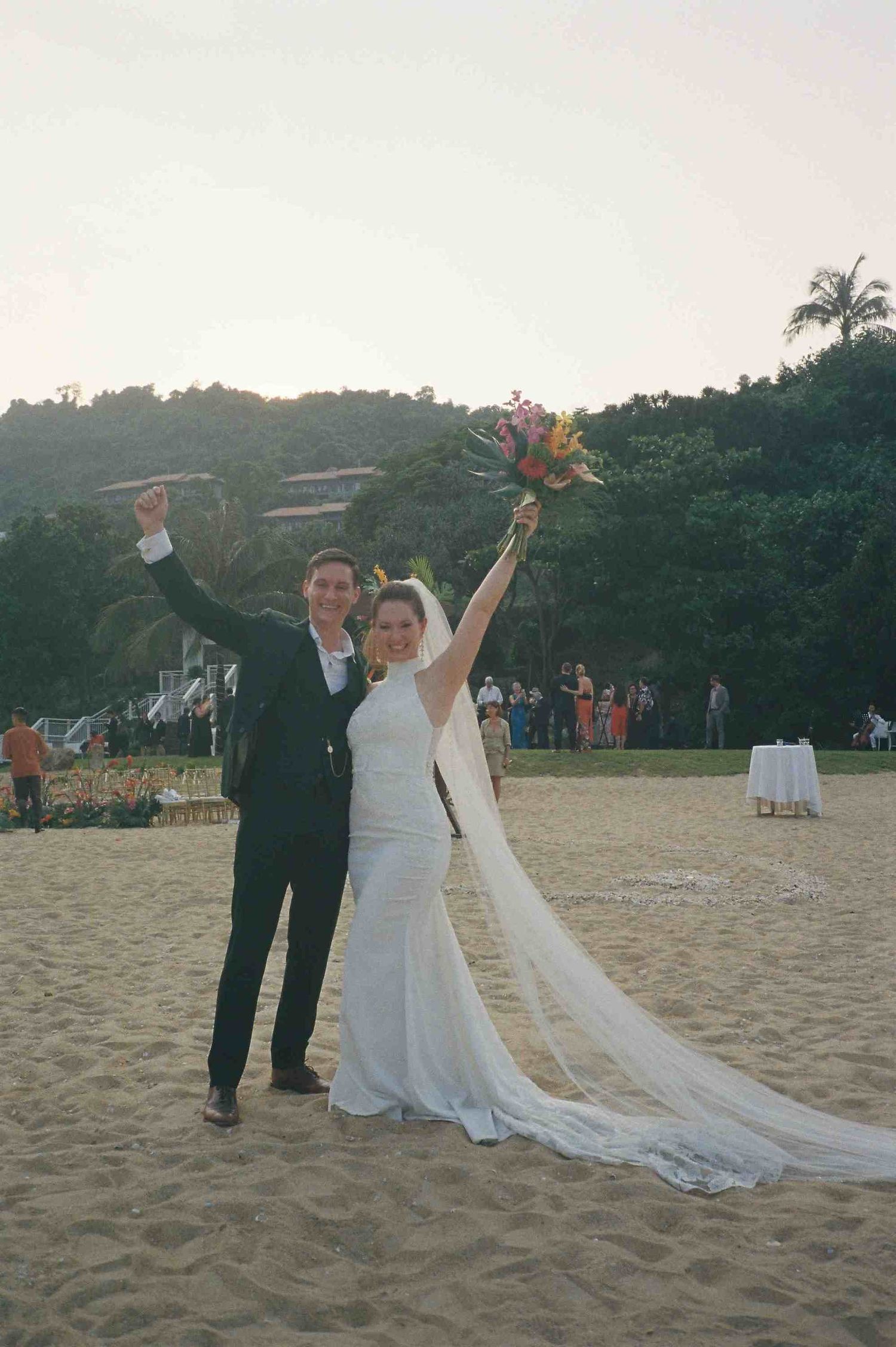 Lang Co wedding: bride and groom celebrating their destination wedding on the beach at Banyan Tree Lang Co, Vietnam, by AnhVuWedding.