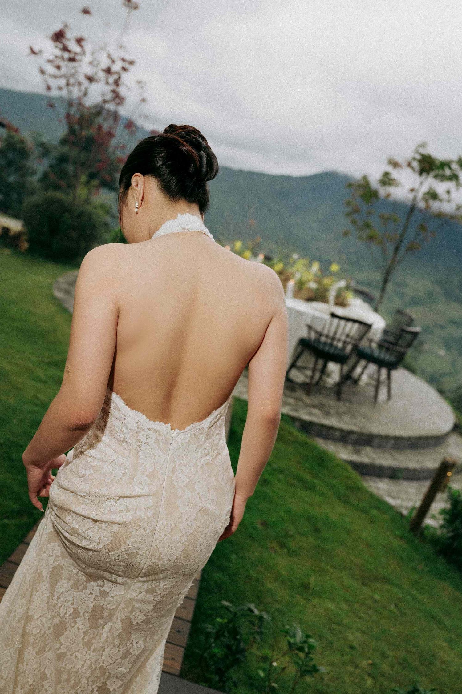 wedding: beaded champagne-colored dress shown from behind against a mountain landscape, by AnhVuWedding.
