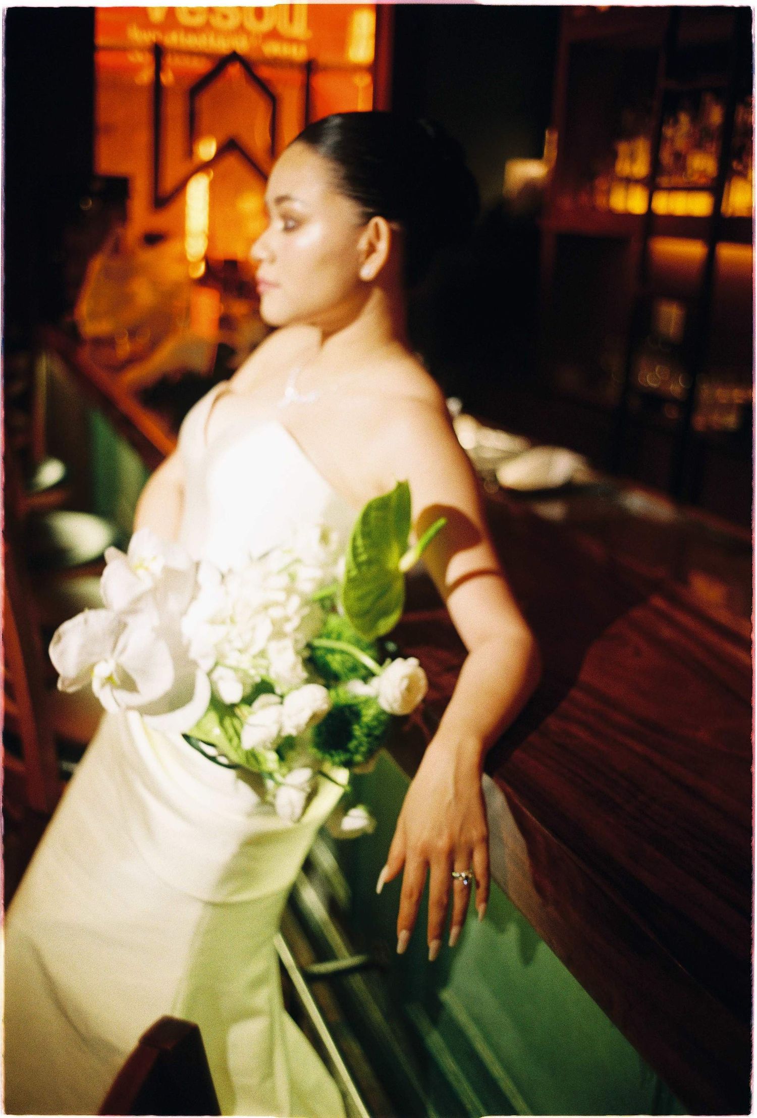 Vietnam pre-wedding: white wedding dress and floral bouquet details in warm lighting, by AnhVuWedding.
