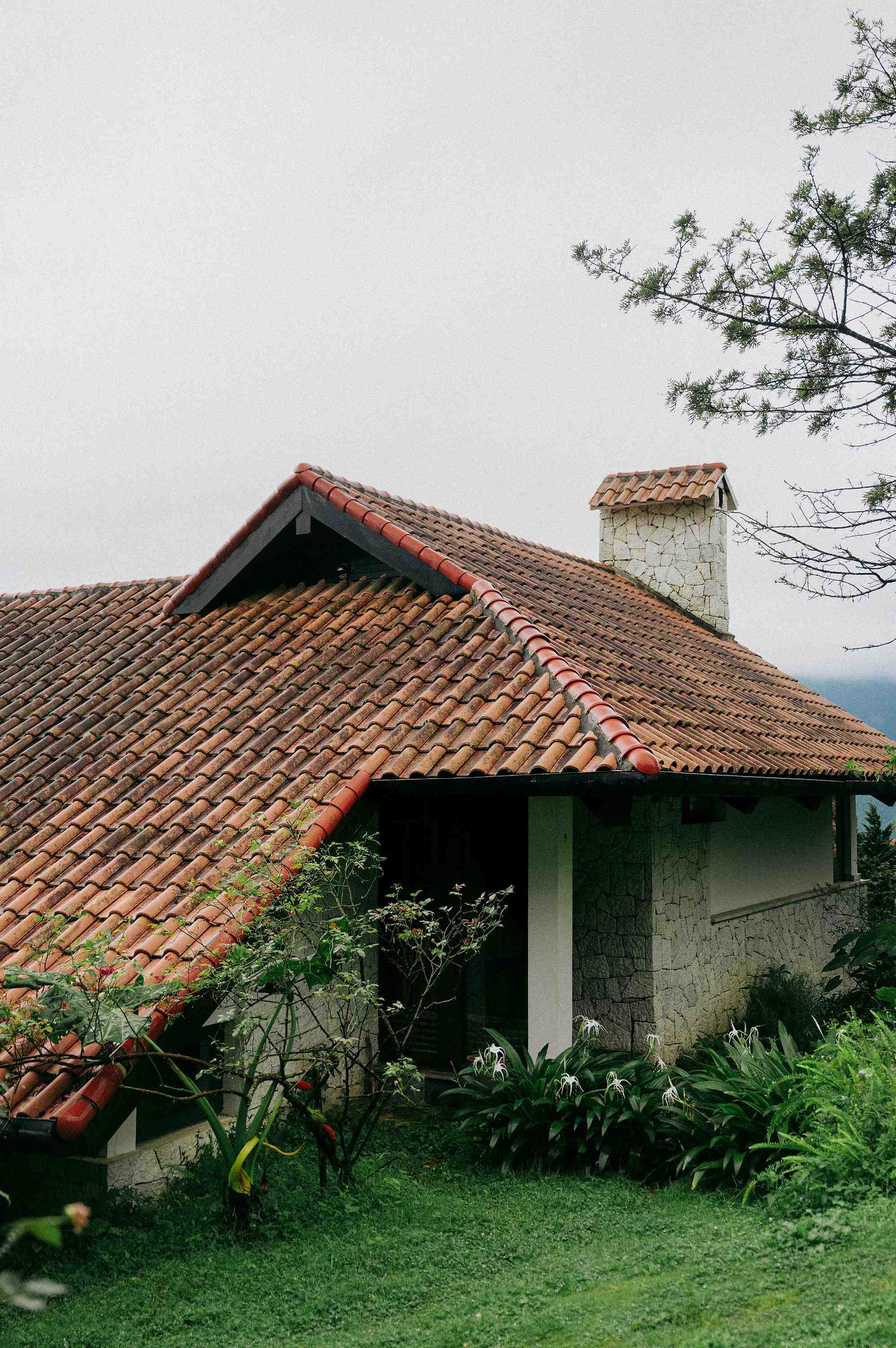 wedding: traditional villa with terracotta roof tiles and white stone walls surrounded by tropical foliage, by AnhVuWedding.