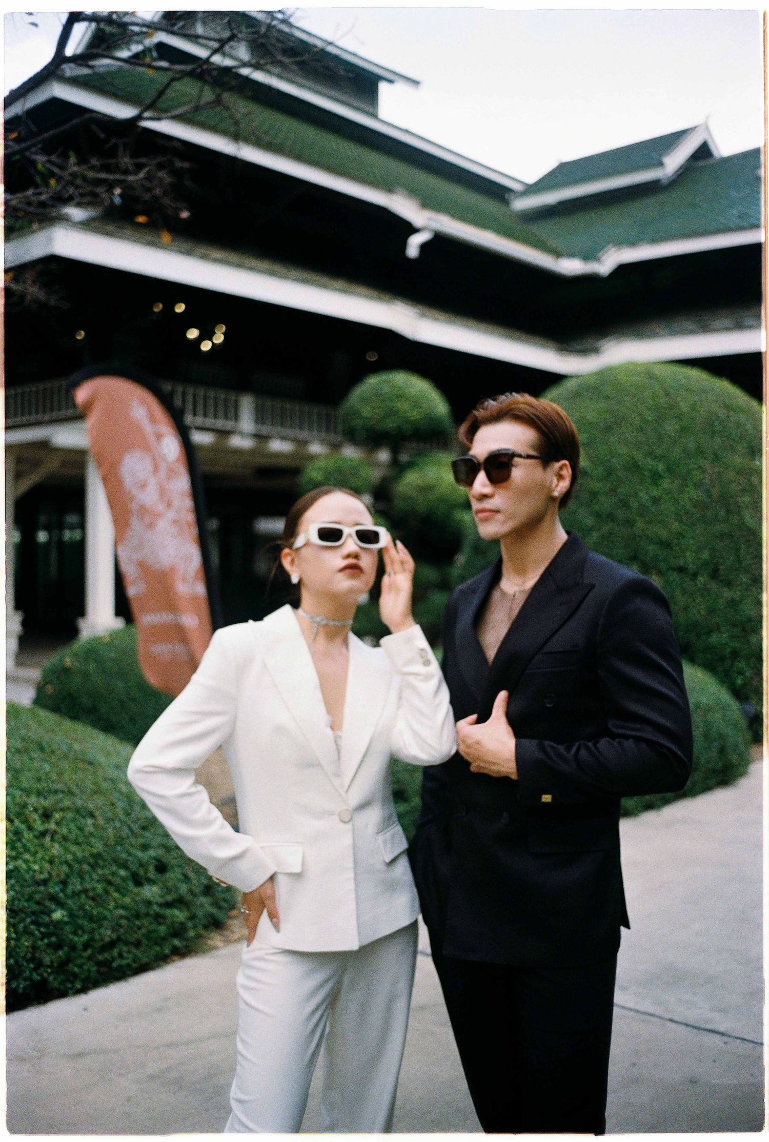 Saigon pre-wedding: couple in sunglasses dancing together outside a Japanese-style building, by AnhVuWedding.