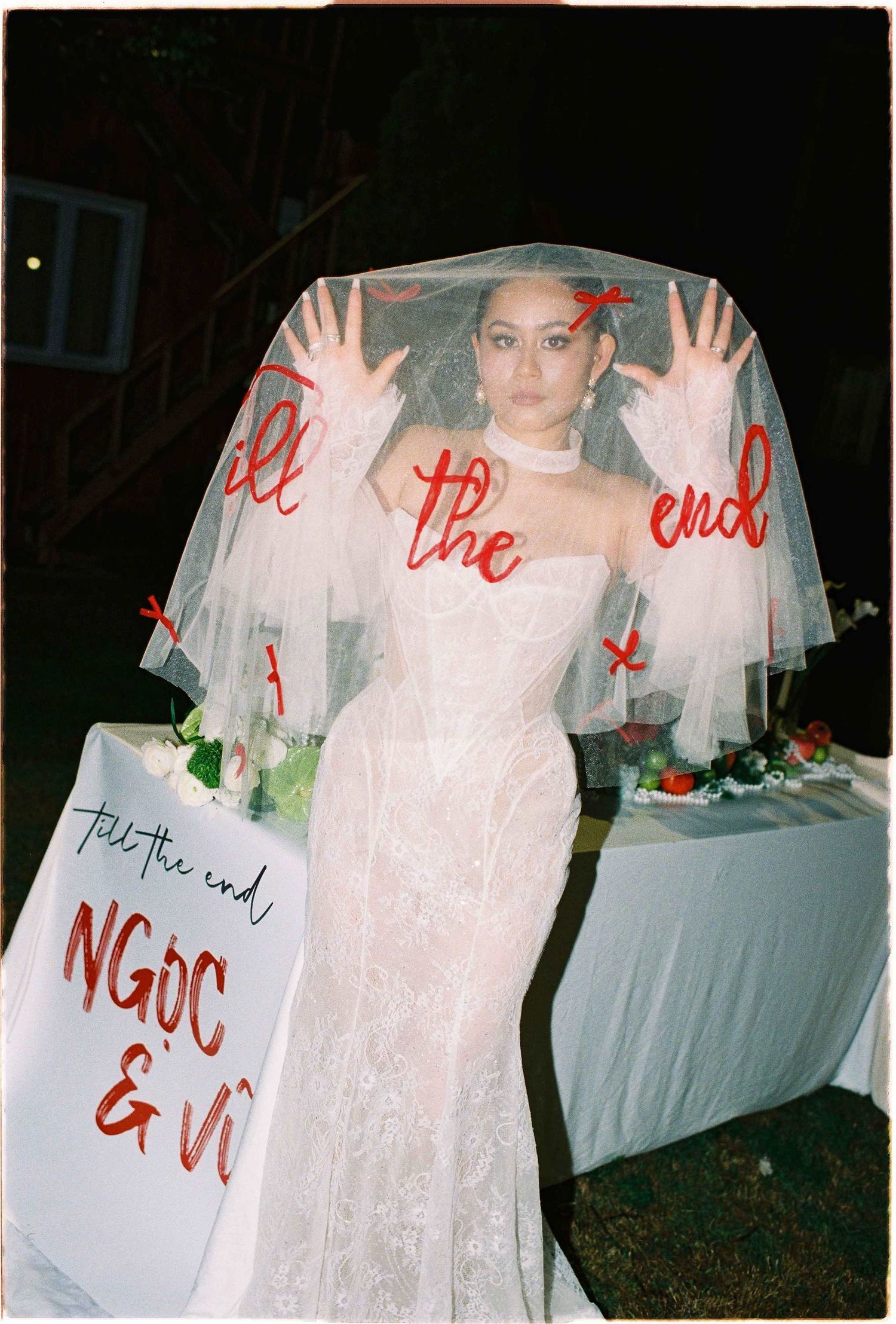 Saigon pre-wedding: bridal portrait with a decorated veil and white table setting in an outdoor evening setting, by AnhVuWedding.