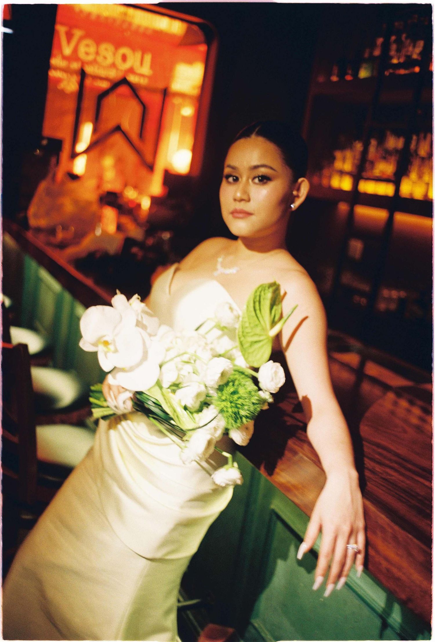 Vietnam pre-wedding: bride with white orchid bouquet poses, by AnhVuWedding.