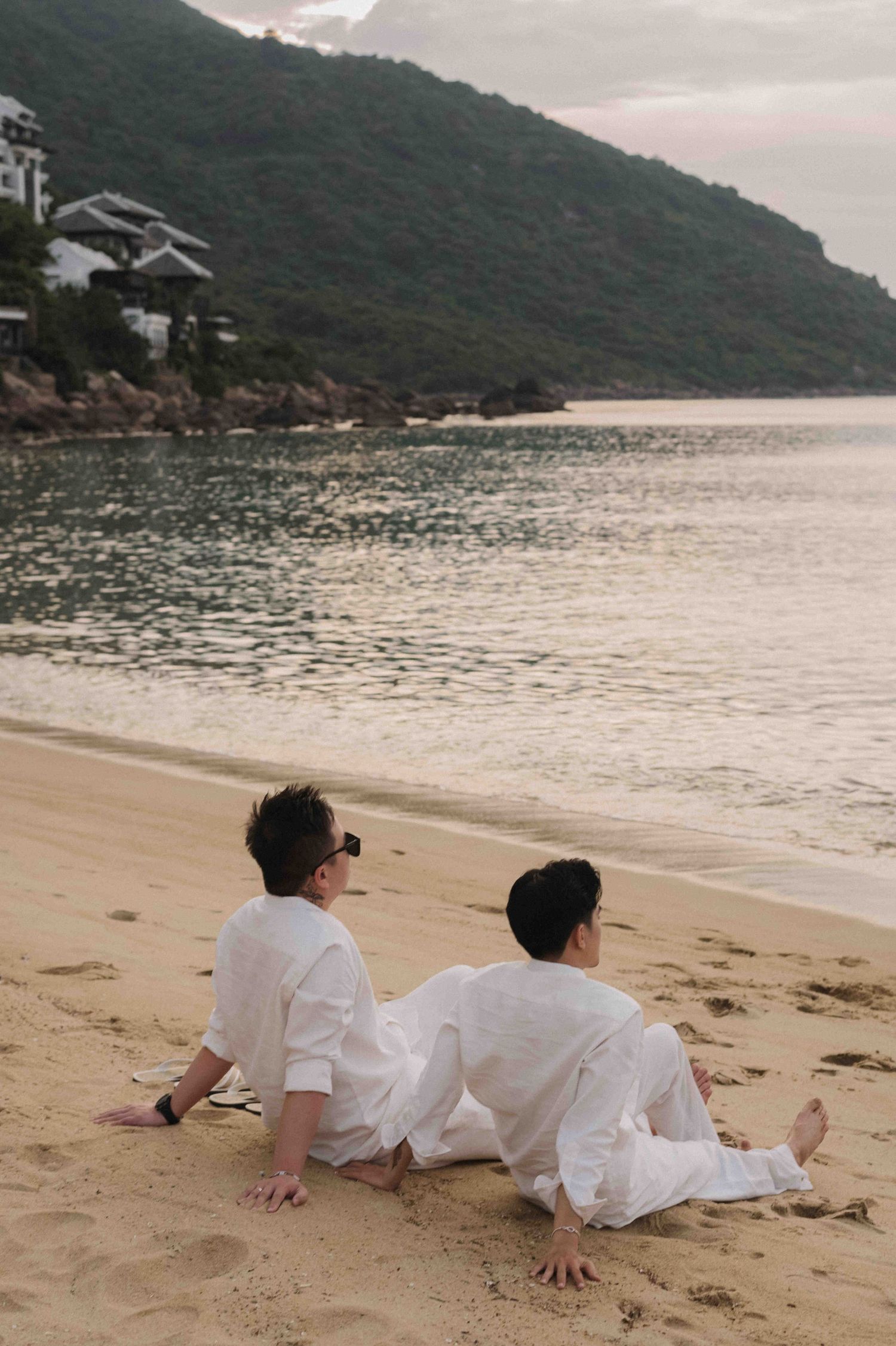 family: couple sitting on the beach at InterContinental Da Nang, captured in a relaxed family and couple photography, by AnhVuWedding.