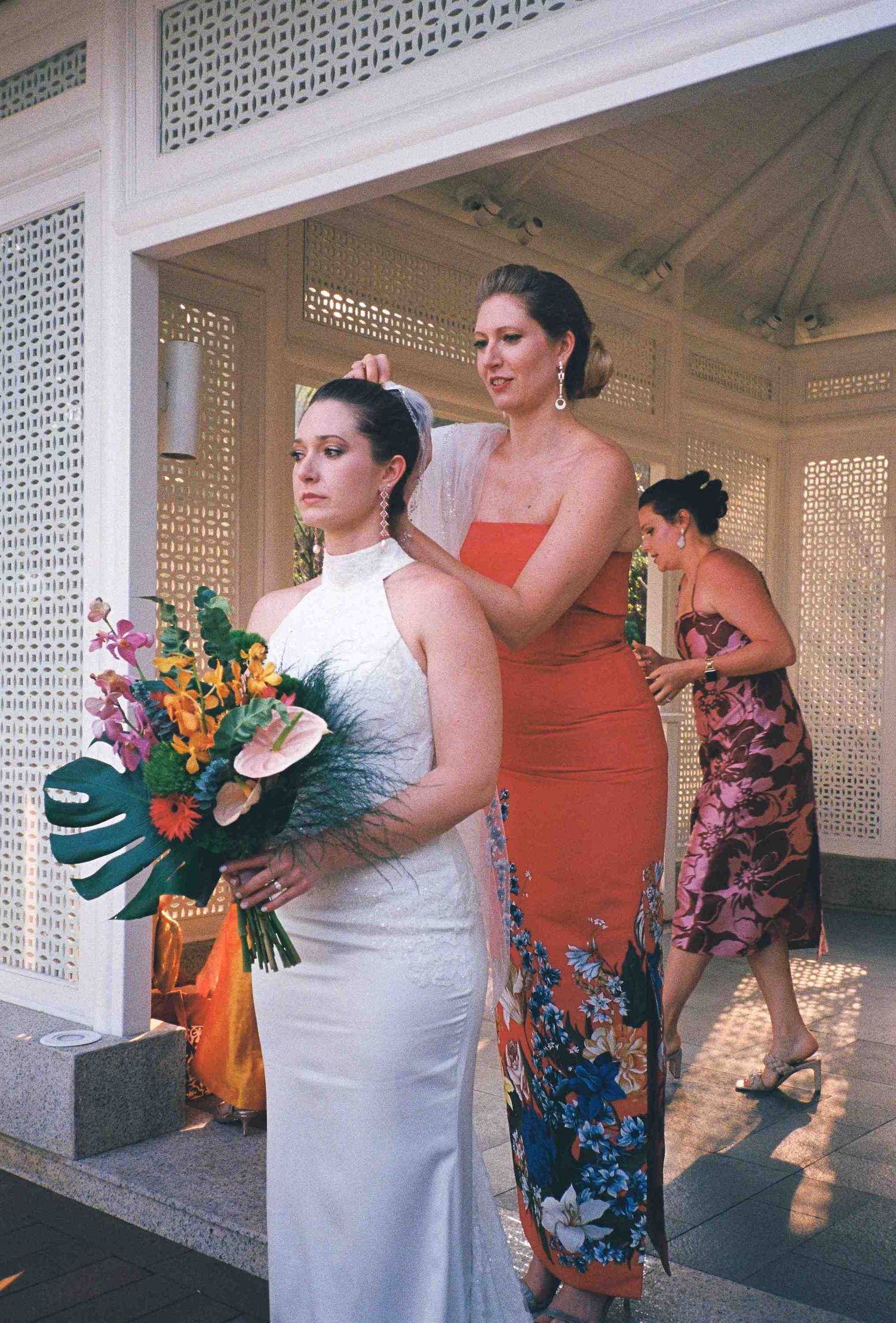 Lang Co wedding: bridal party posing with colorful tropical bouquets in an elegant white pavilion, by AnhVuWedding.