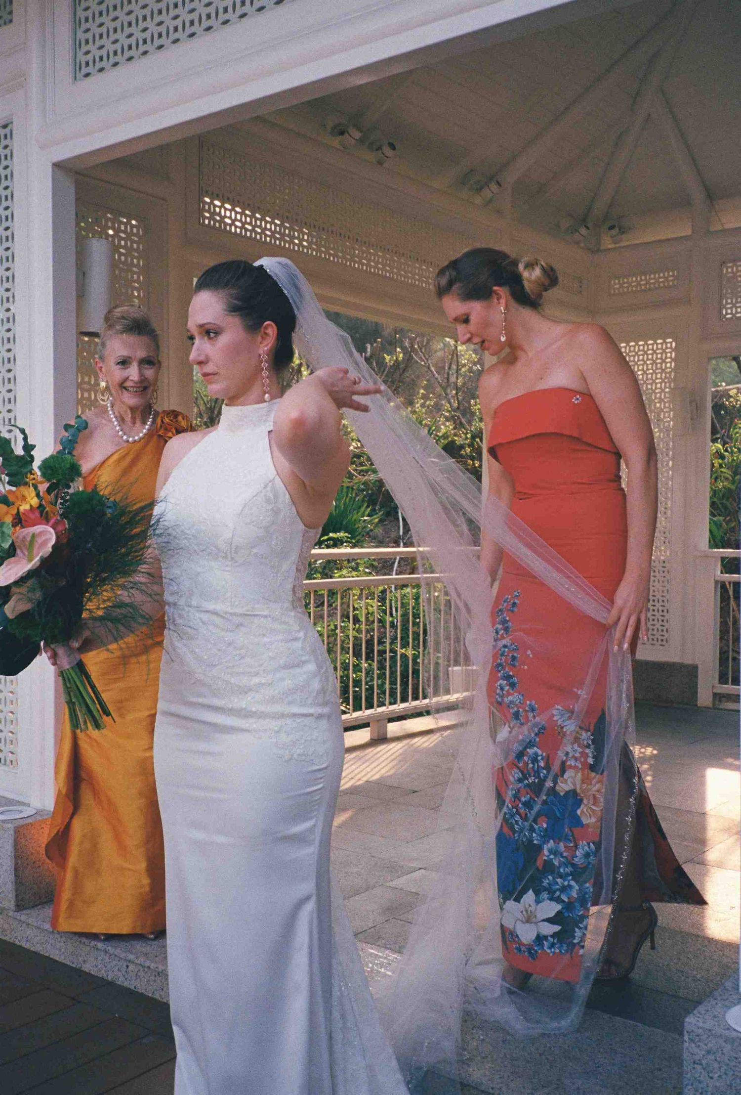 Lang Co wedding: wedding party gathering in a covered outdoor pavilion with tropical floral arrangements, by AnhVuWedding.