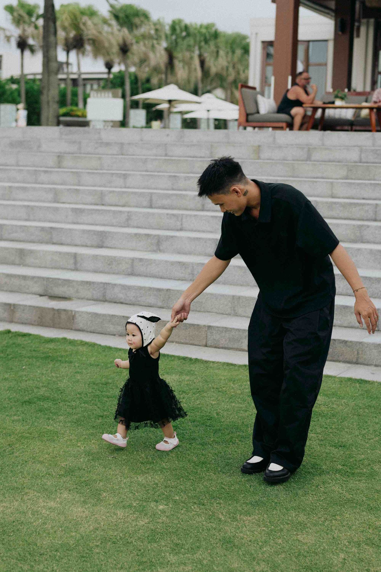Da Nang family: candid outdoor photoshoot on grassy steps, by AnhVuWedding.