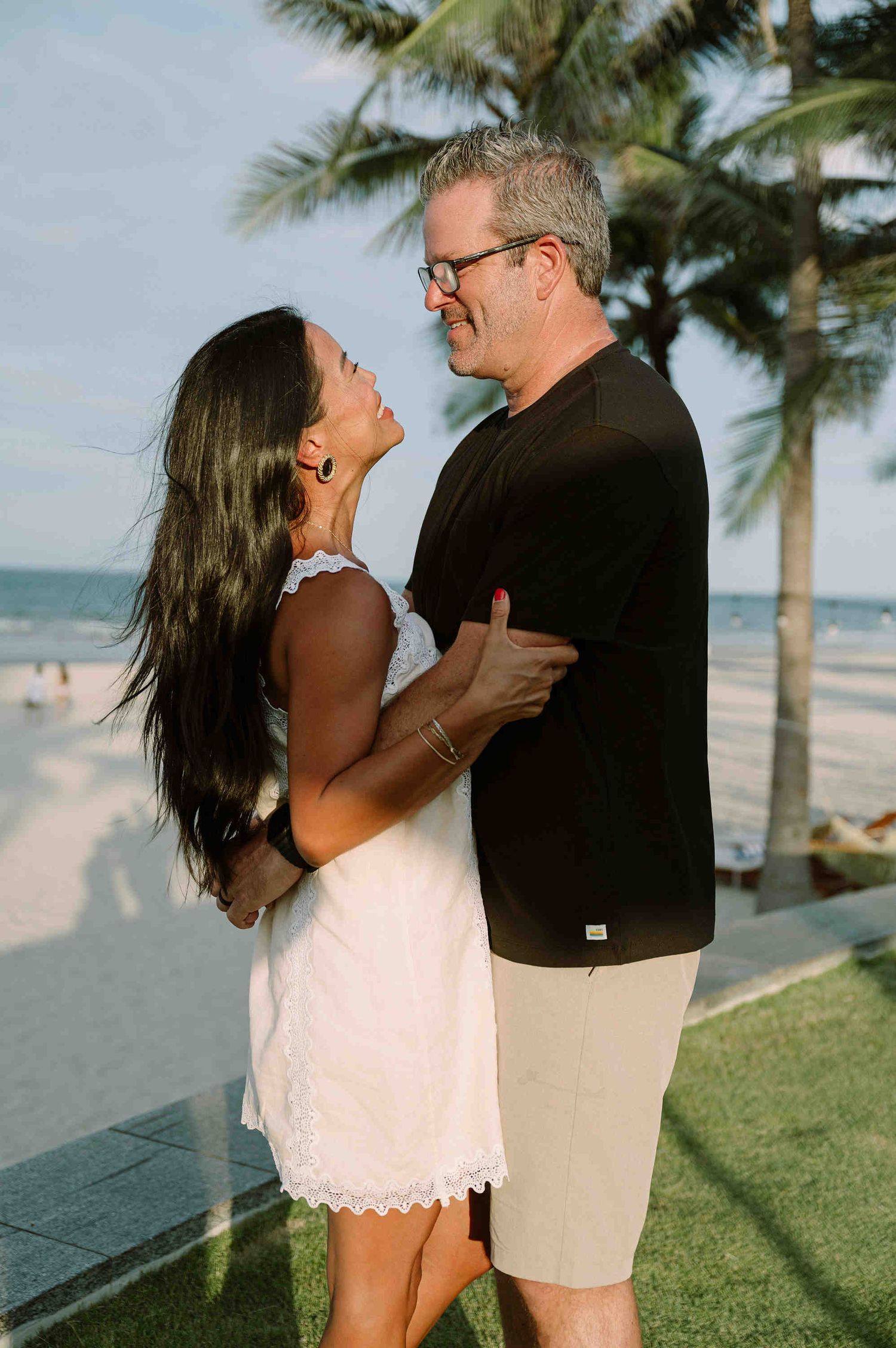 Da Nang family: romantic couple embraces and laughs together on a sunny beach, by AnhVuWedding.