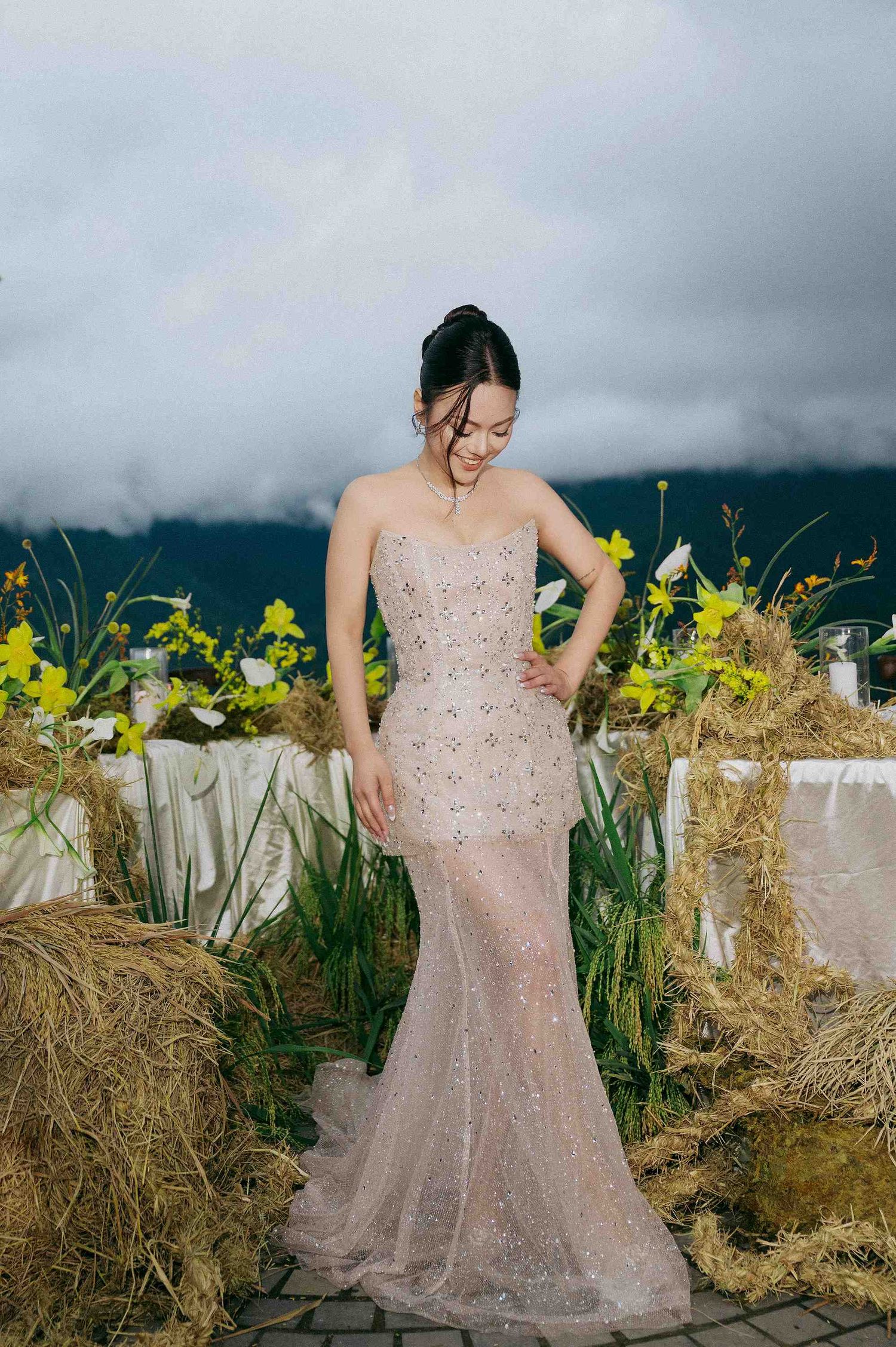 wedding: wedding venue decorated with hay bales and yellow flowers on stone patio with mountain views, by AnhVuWedding.