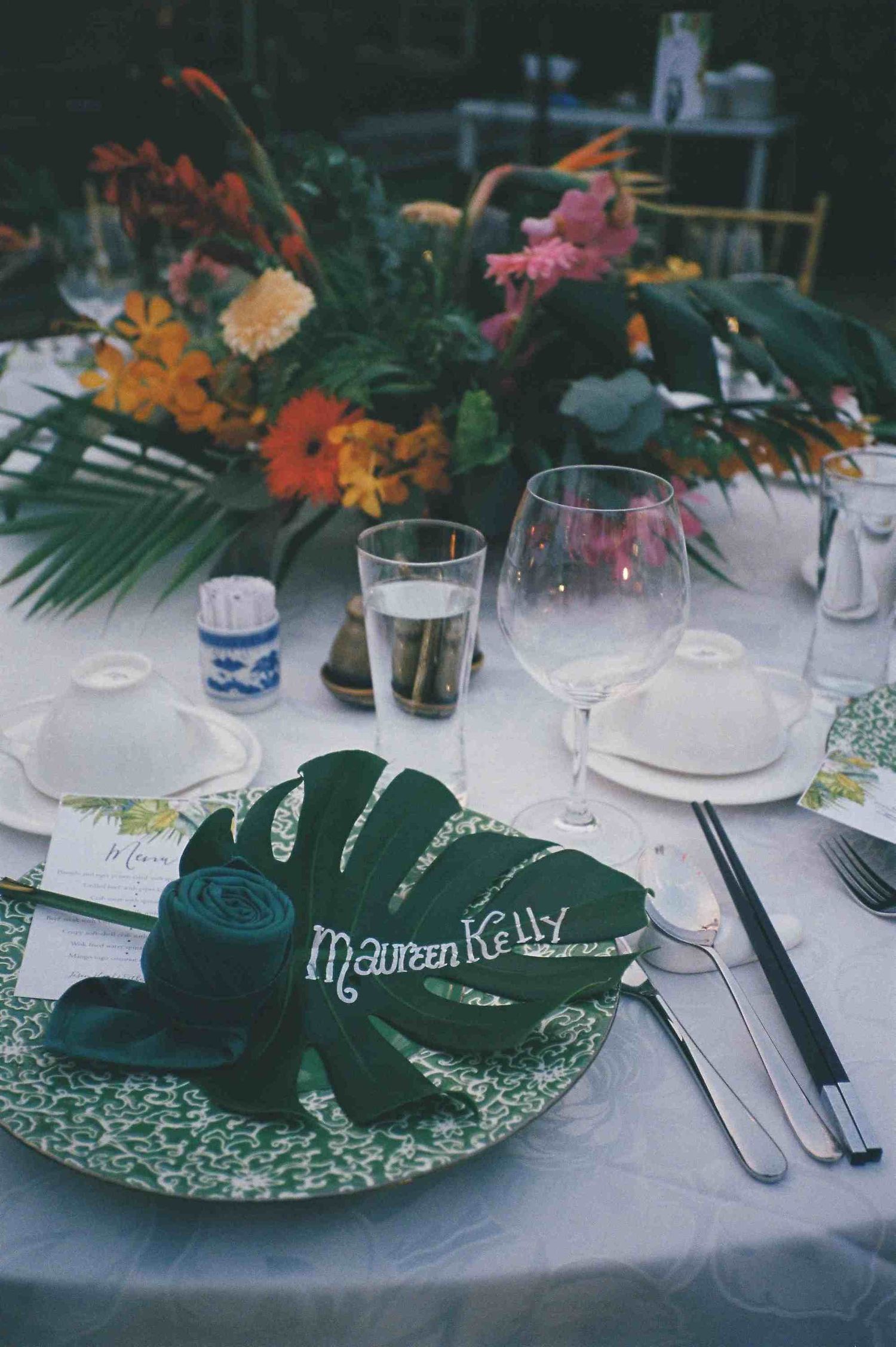 Lang Co wedding reception: elegant table settings with tropical floral centerpieces and decorative plates at a wedding, by AnhVuWedding.