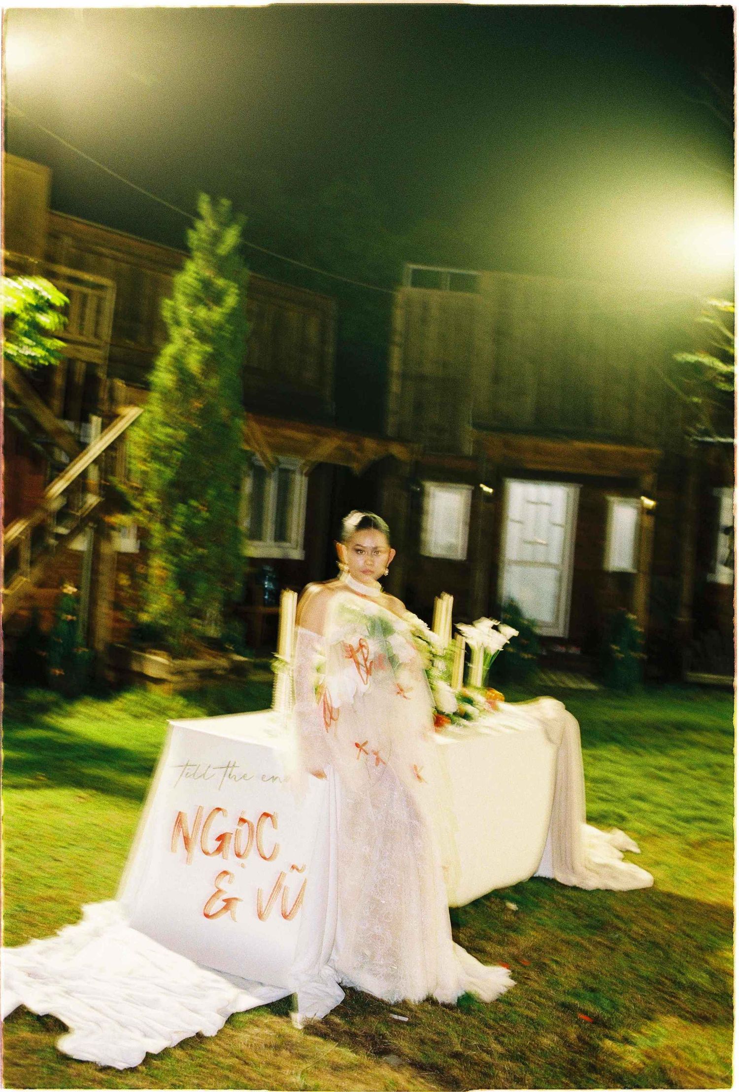 Saigon pre-wedding: outdoor evening wedding scene with a decorated white table and floral arrangements, by AnhVuWedding.