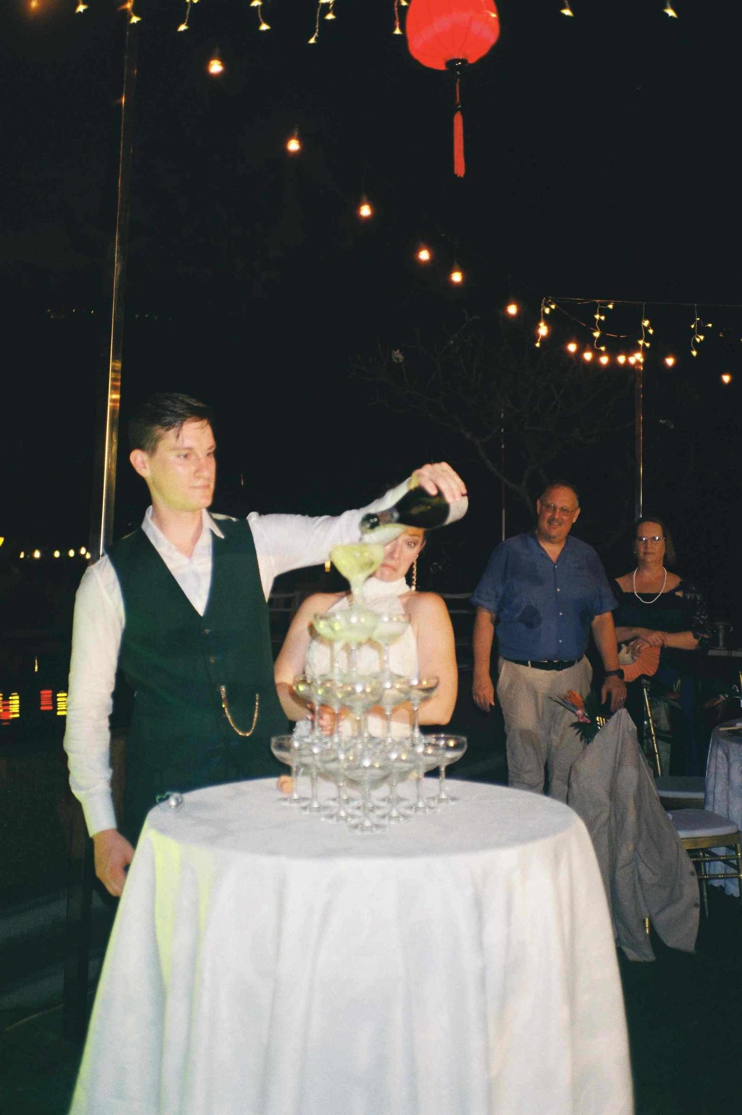 Lang Co wedding reception: wedding reception table setup with champagne glasses and string lights creating a, by AnhVuWedding.