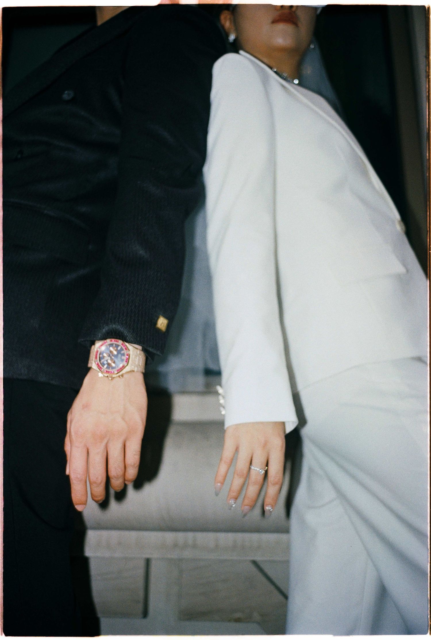 Saigon pre-wedding: close-up detail shot of hands and white clothing against a dark background, by AnhVuWedding.