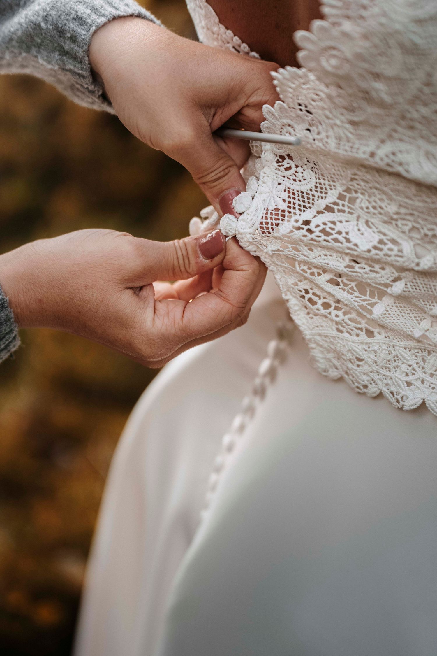 Detailaufnahme beim Schliessen des Brautkleids