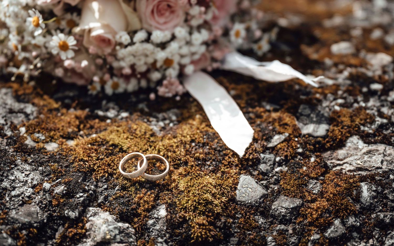 Eheringe und Brautstrauss als Hochzeitsdetail in der Natur