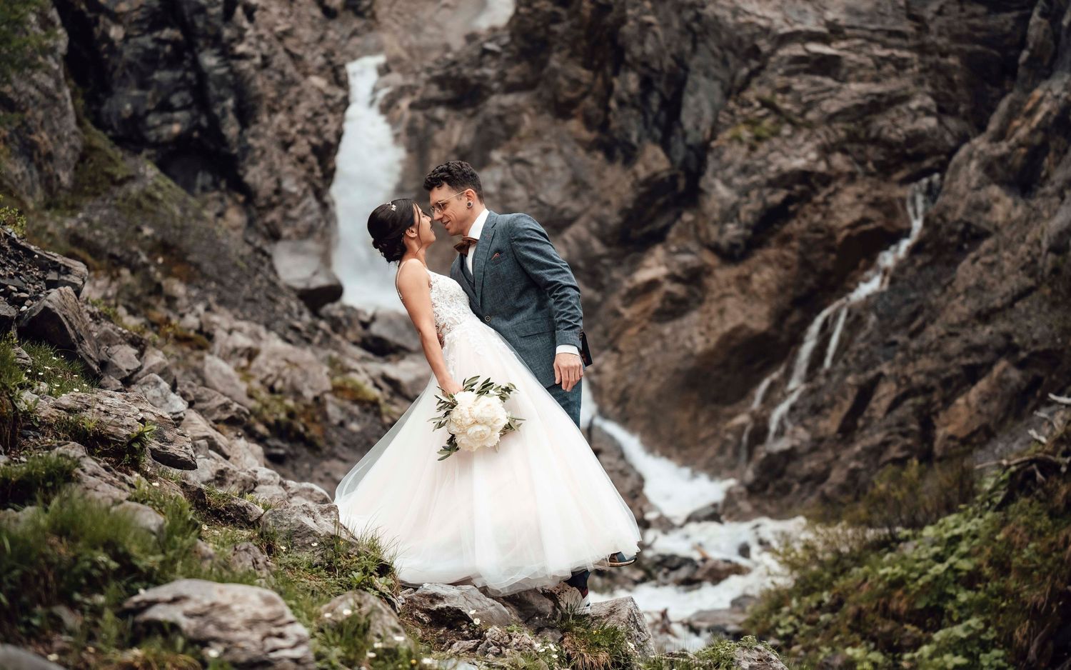 Hochzeitspaar vor Wasserfall in den Schweizer Bergen