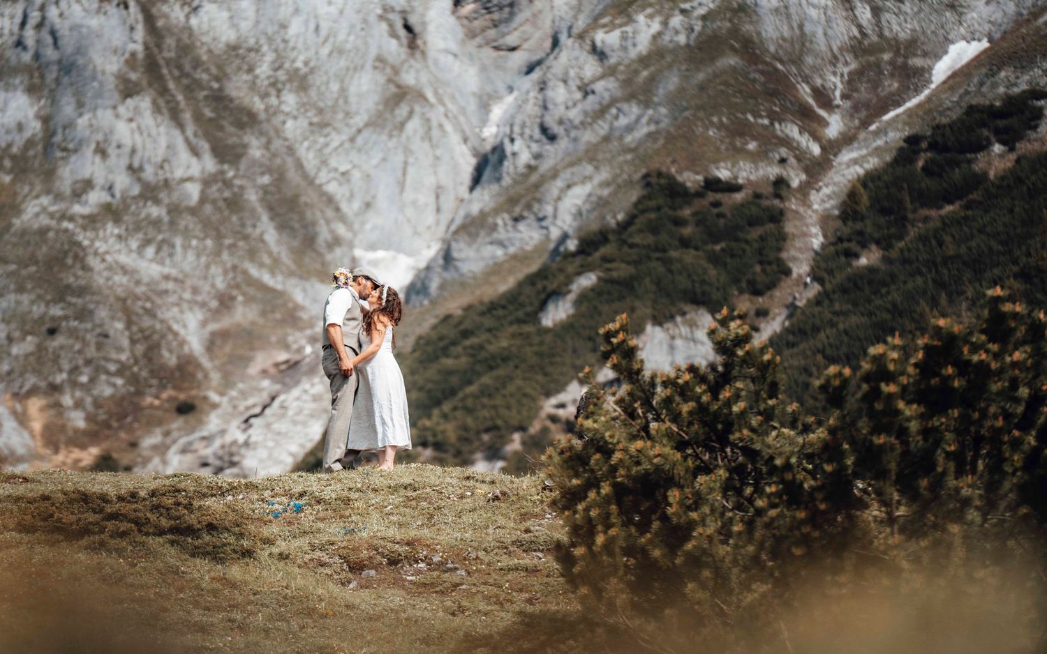 Brautpaar in weiter Berglandschaft während des Hochzeitsshootings