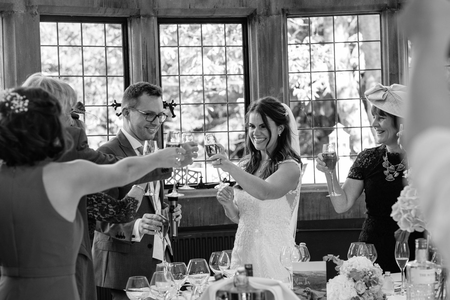 Wedding reception gathering in a bright indoor venue with large windows - by Norfolk and Norwich Wedding Photographer.