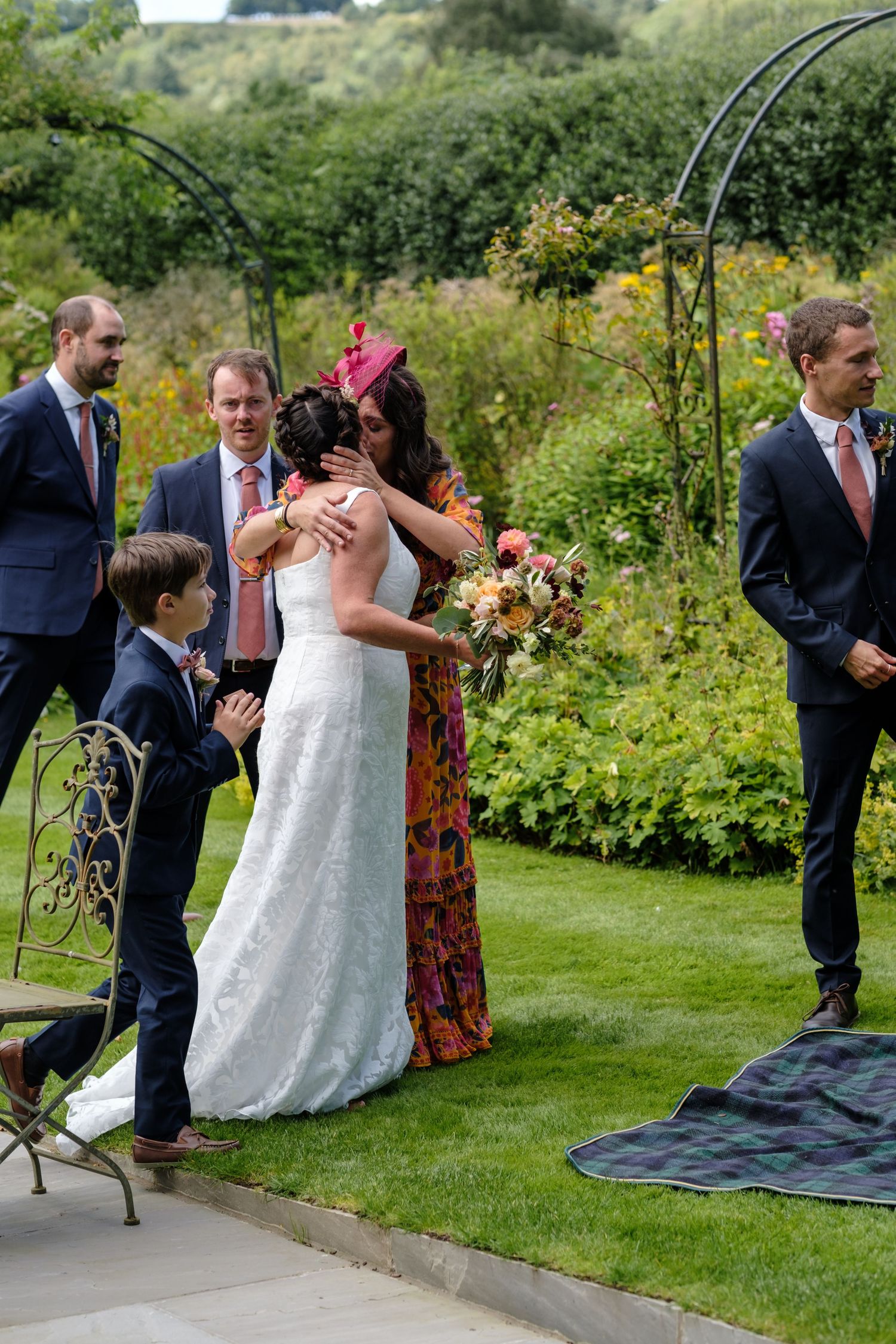 Wedding guests mingle on a lush green lawn during an outdoor garden reception. Norfolk and Norwich wedding photographer.