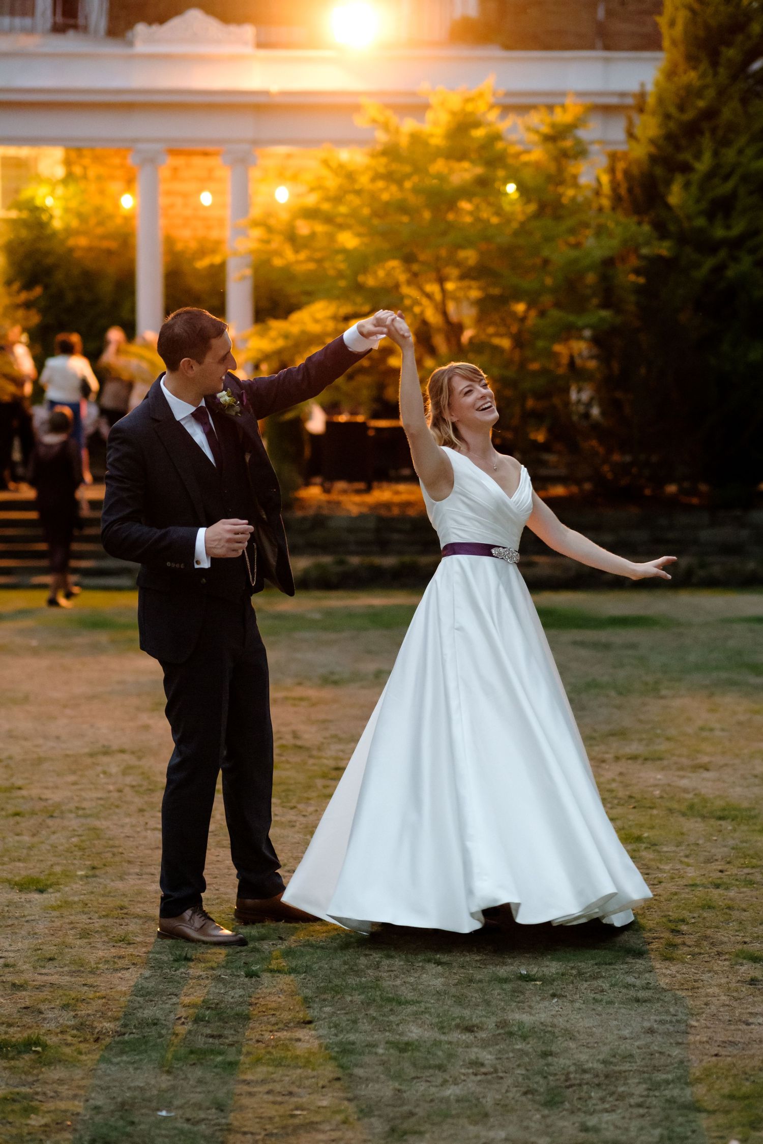 Bride and groom dancing outside at sunset - by Norfolk and Norwich wedding photographer