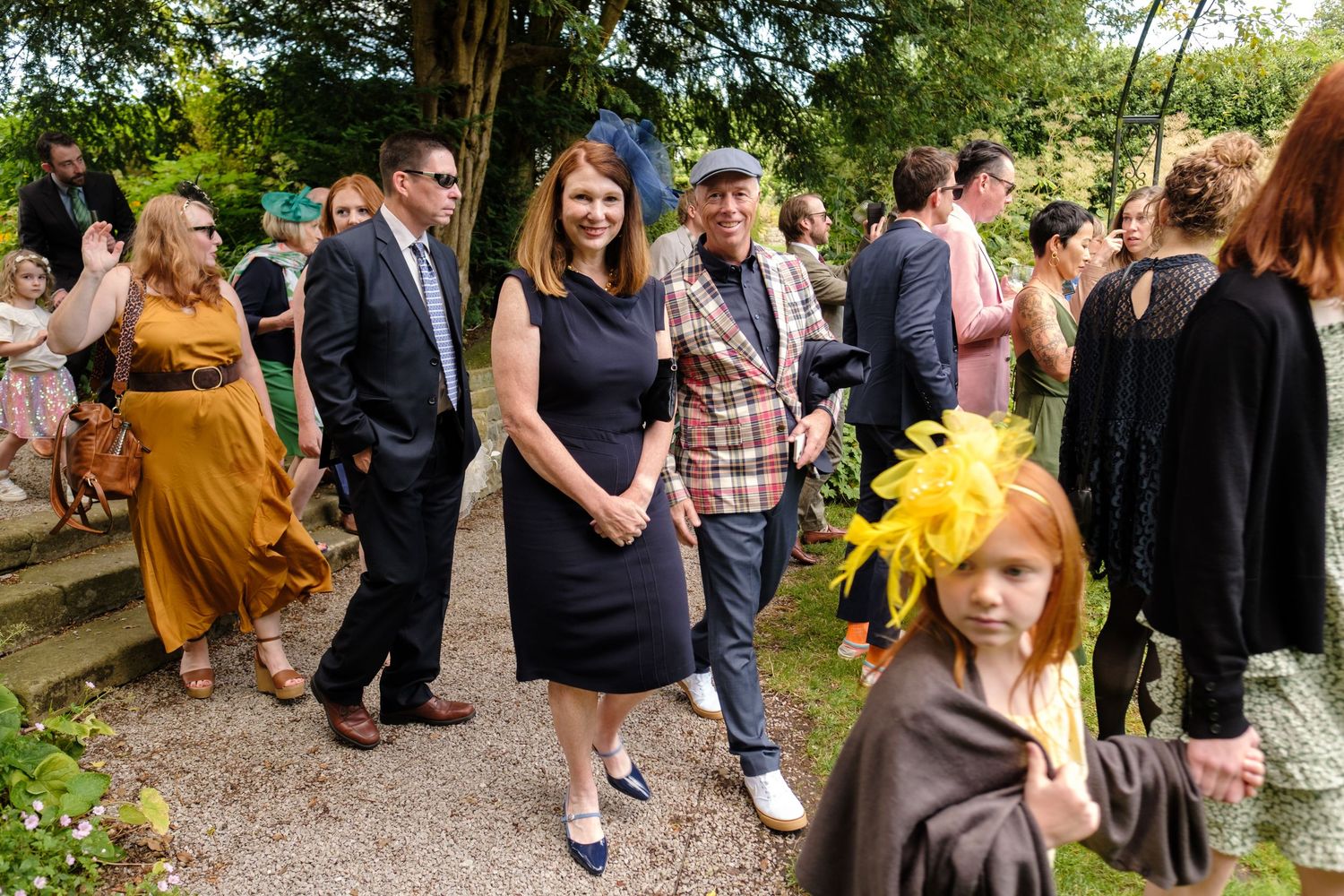 Guests gather on a stone pathway during an outdoor wedding reception. Norfolk and Norwich wedding photographer.