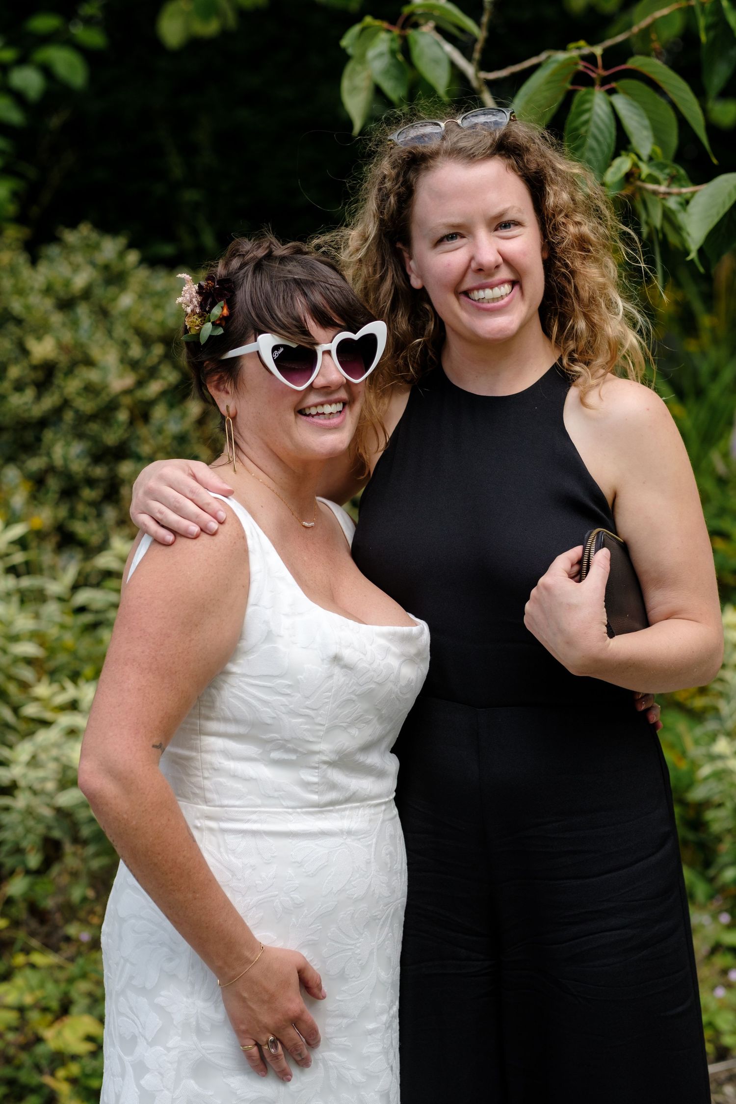 Friends celebrating at a garden wedding wearing black and white dresses. Norfolk and Norwich wedding photographer.