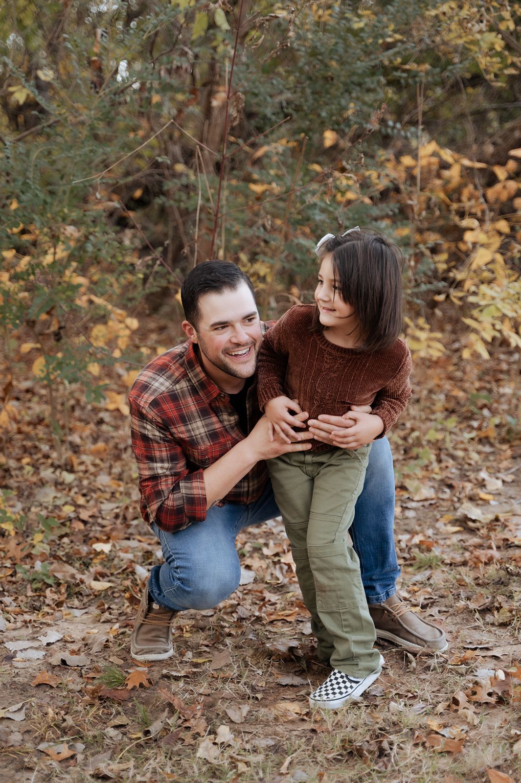 Playful father and daughter moment captured by Tulsa family photographer during a fun outdoor fall family session