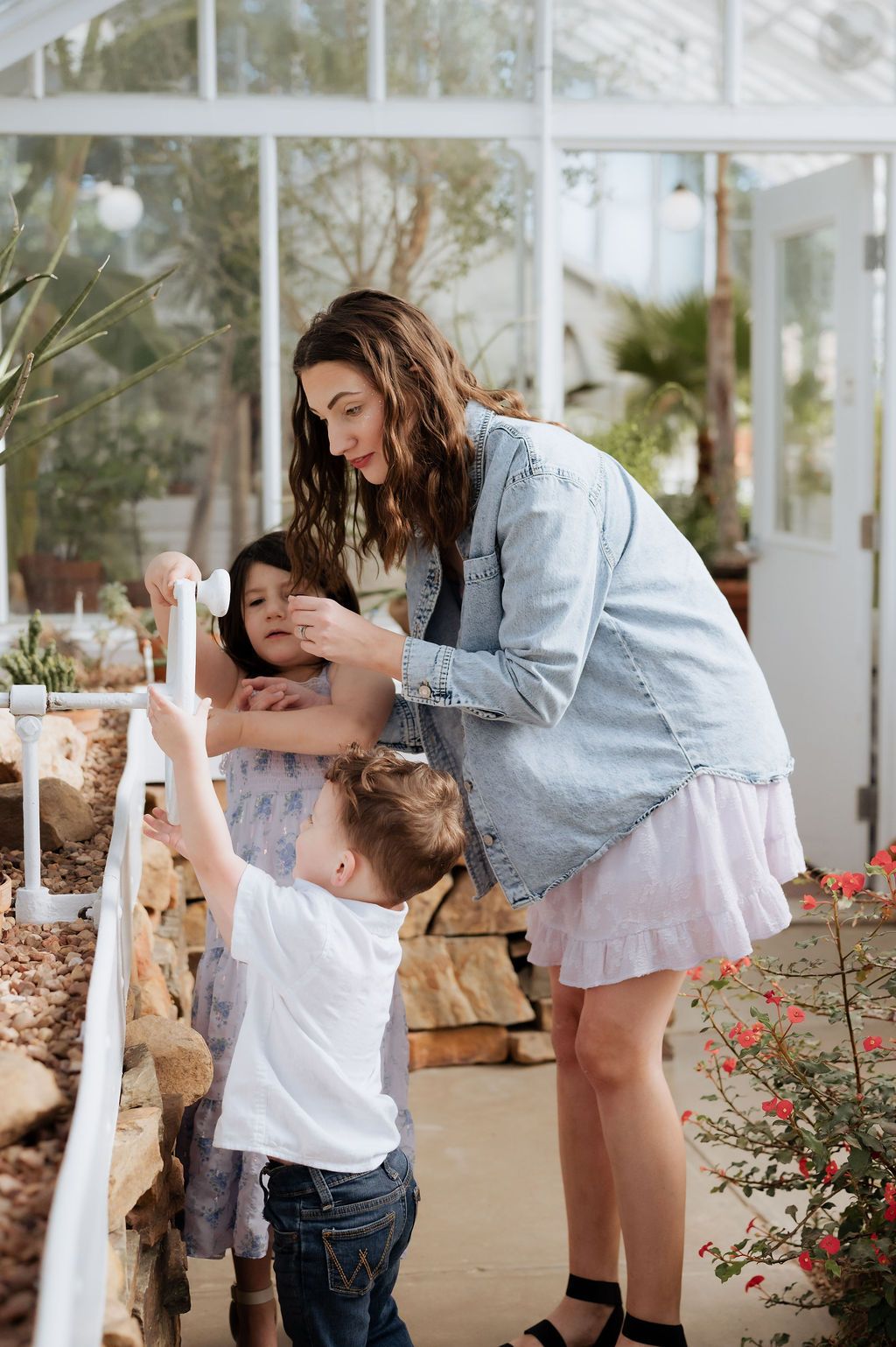 Mom and children enjoying a candid greenhouse moment during a Tulsa mini photography session