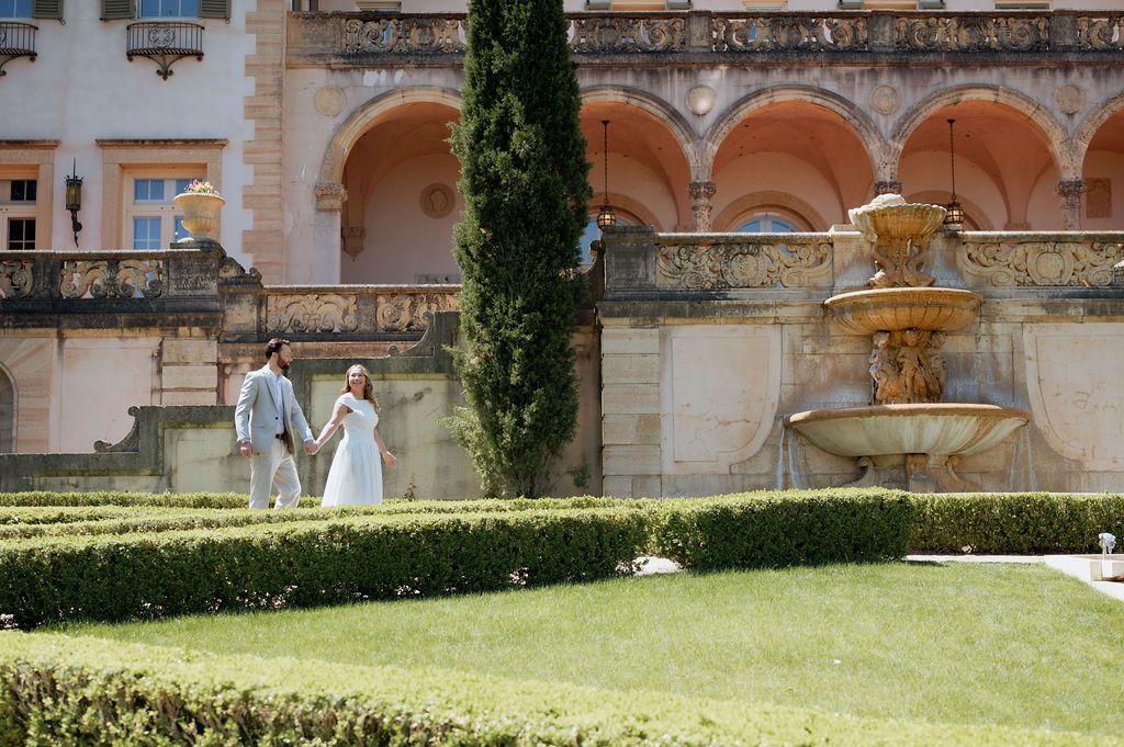 Couple walking through the formal gardens for engagement photos at the Philbrook