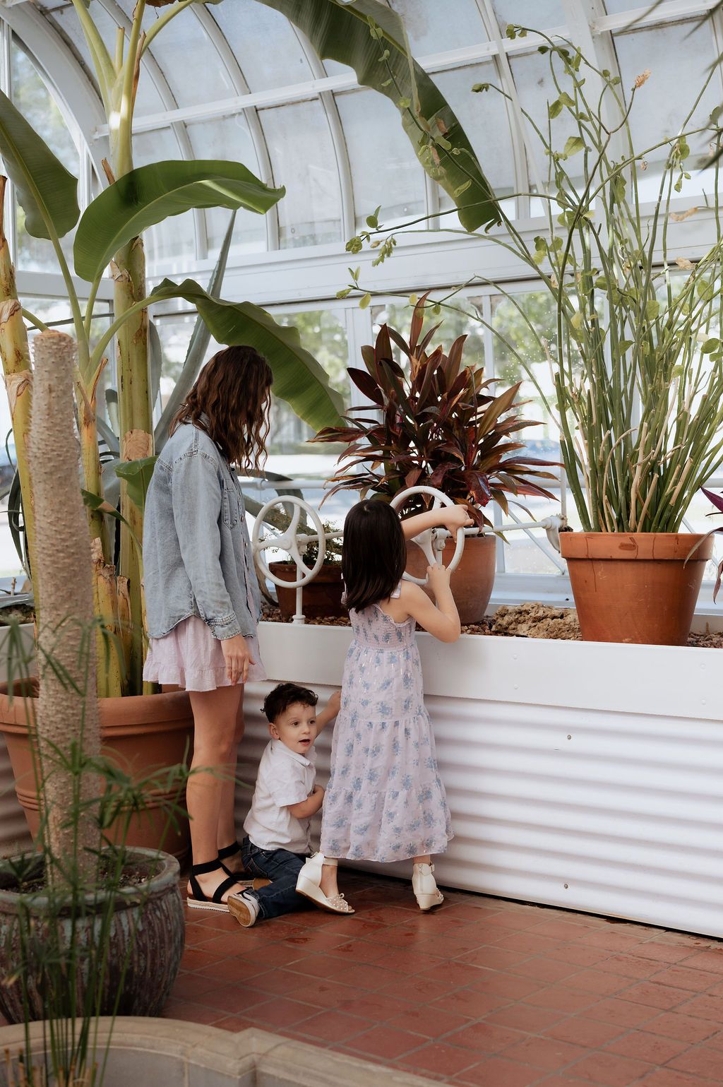 Mother and children exploring the greenhouse at Woodward Park during a Tulsa motherhood photography session